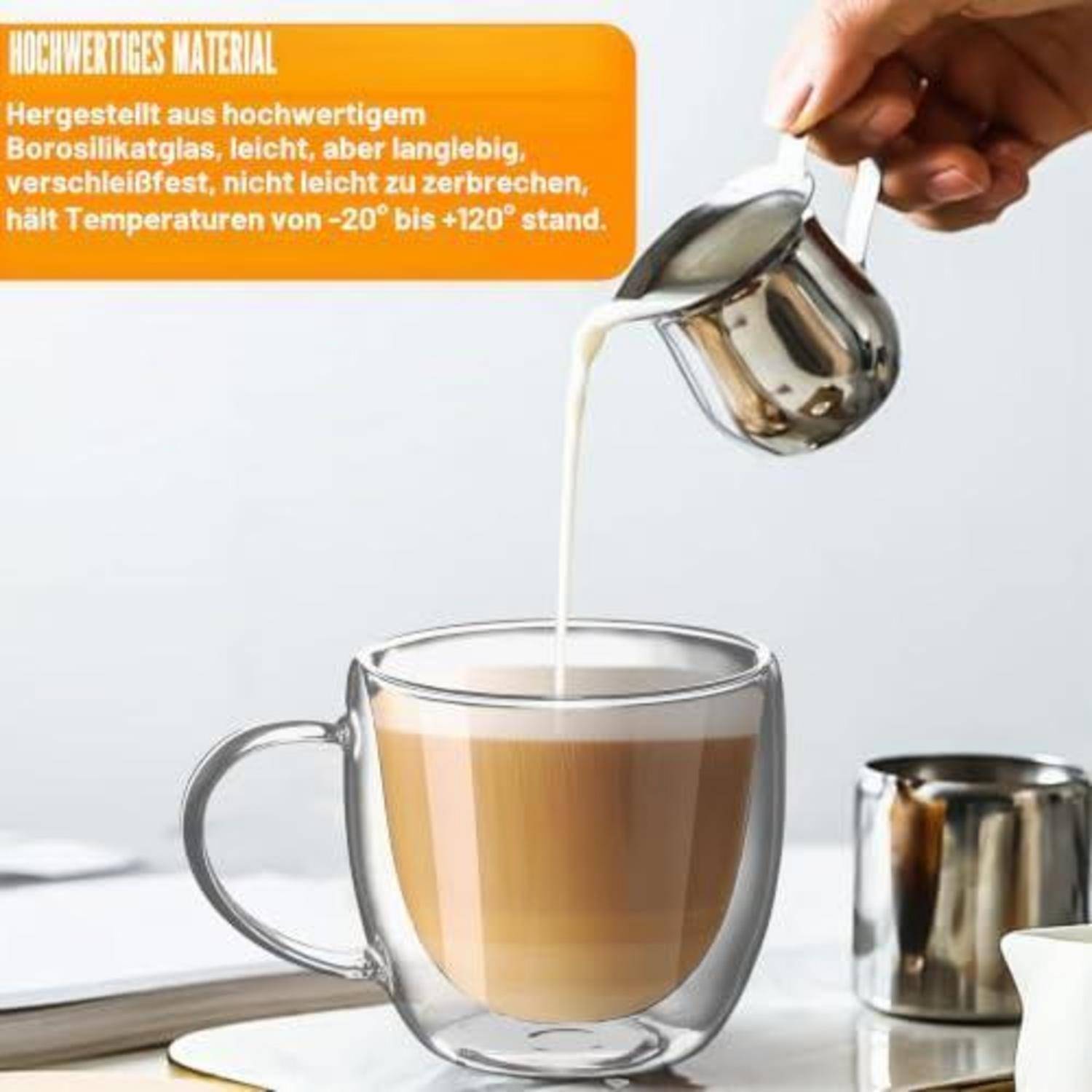 Milch wird aus einem Edelstahlkrug in eine doppelwandige Glaskaffeetasse gegossen; der Text hebt hitzebeständiges Borosilikatglas hervor.