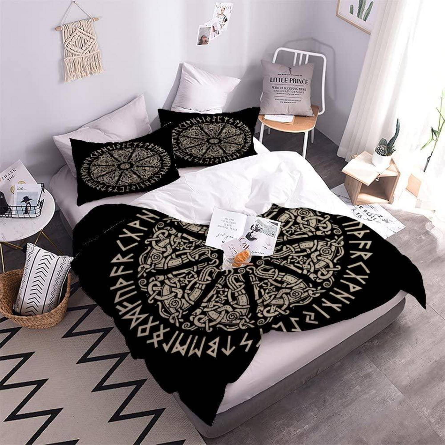 Gemütliches minimalistisches Schlafzimmer mit einem niedrigen Bett, schwarzer gemusterter Bettwäsche und Kissen, Wanddekoration, kleinem Stuhl, Beistelltischen und hellem Fensterlich.
