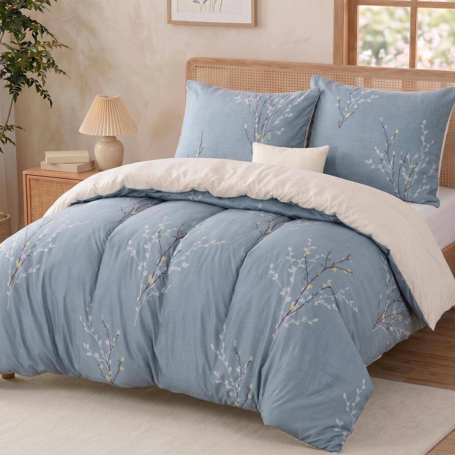 Ein ordentlich gemachtes Bett mit hellblauer Blumenbettwäsche, weißen Kissen und einem geflochtenen Kopfteil in einem hellen Schlafzimmer.