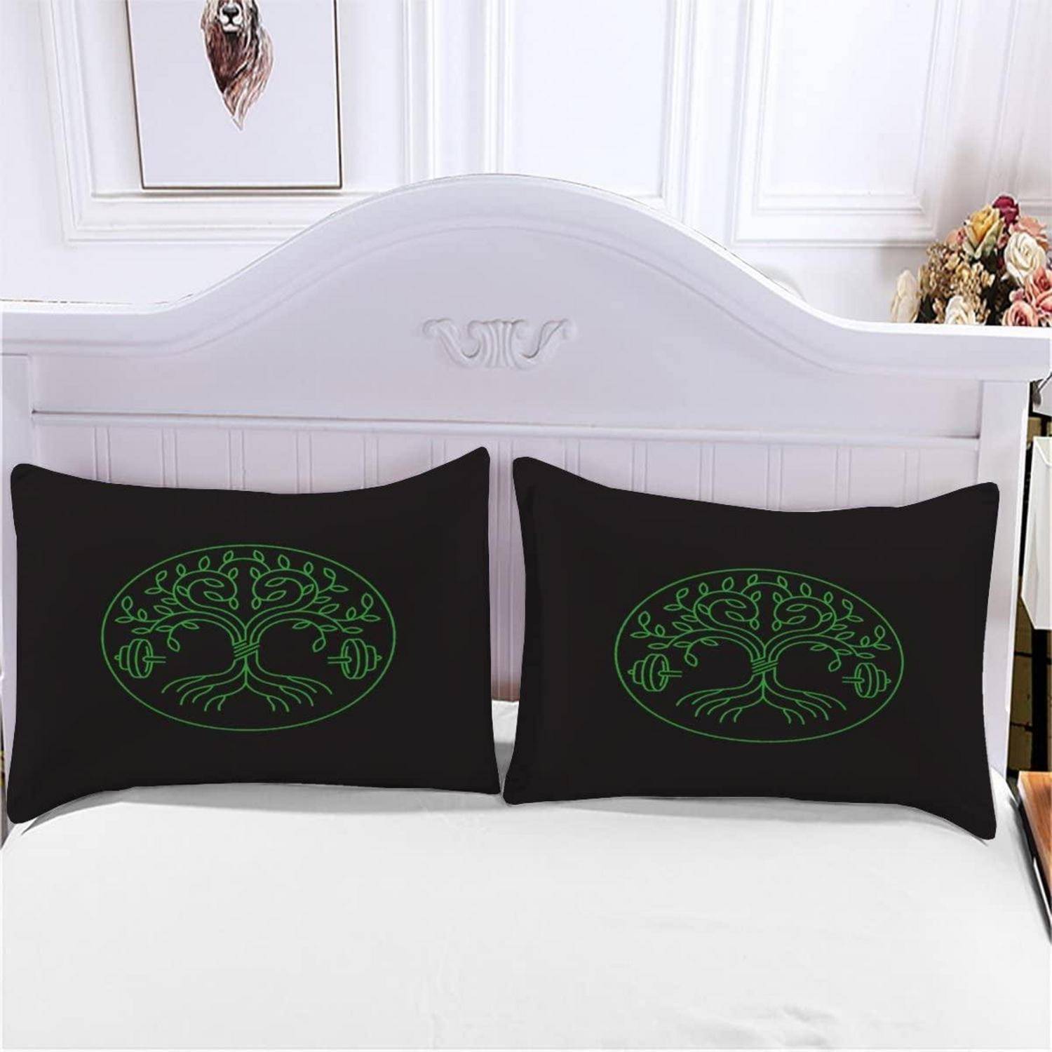 Zwei schwarze Kissen mit grünen Baummotiven sind auf einem weißen Bett gegen ein weißes Kopfteil in einem hellen Schlafzimmer angeordnet.