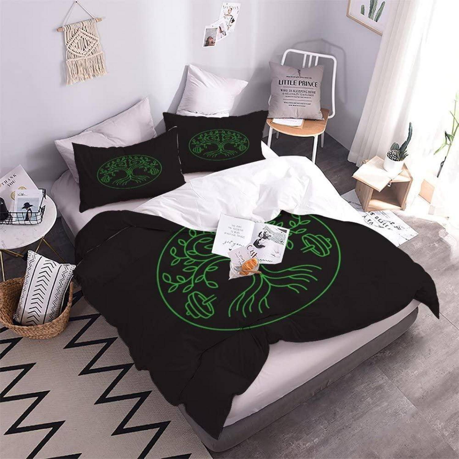 Ein sorgfältig gemachtes Bett mit schwarzer Bettwäsche mit grünen Linienzeichnungen, Kissen, Bücher und kleine Dekoration in einem hellen minimalistischen Schlafzimmer.