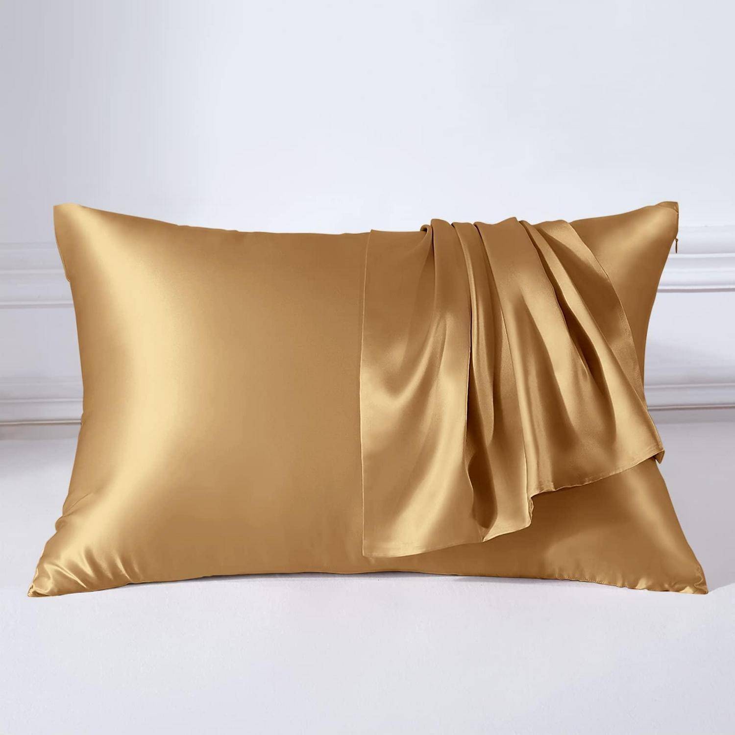 Goldenes Satinkissen mit dekorativem Drapiervolant auf weißem Hintergrund.