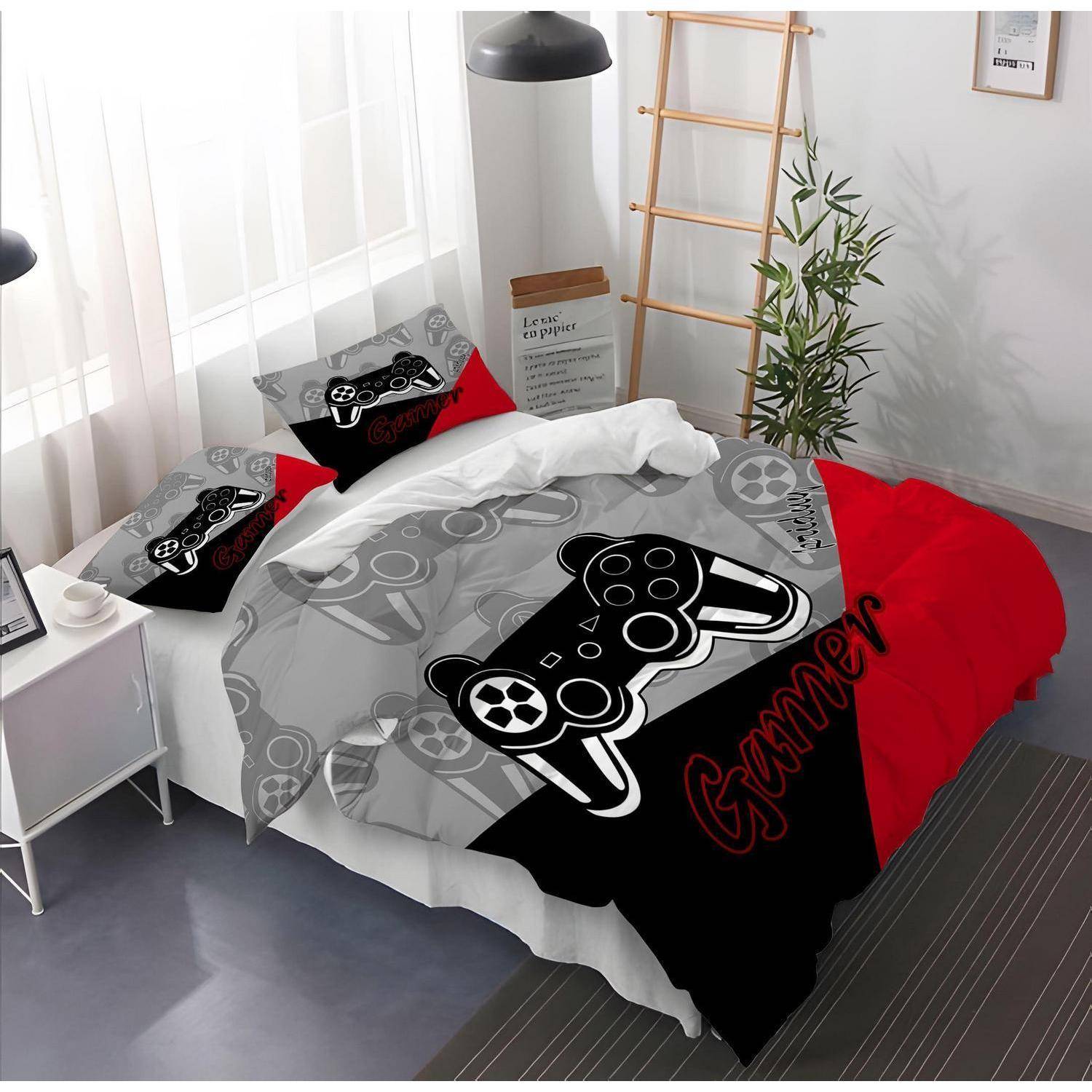 Schlafzimmer mit einer Gaming-Bettwäsche, Kissenbezügen und einer Decke, die Spielcontroller und das Wort "Gamer"" zeigen.