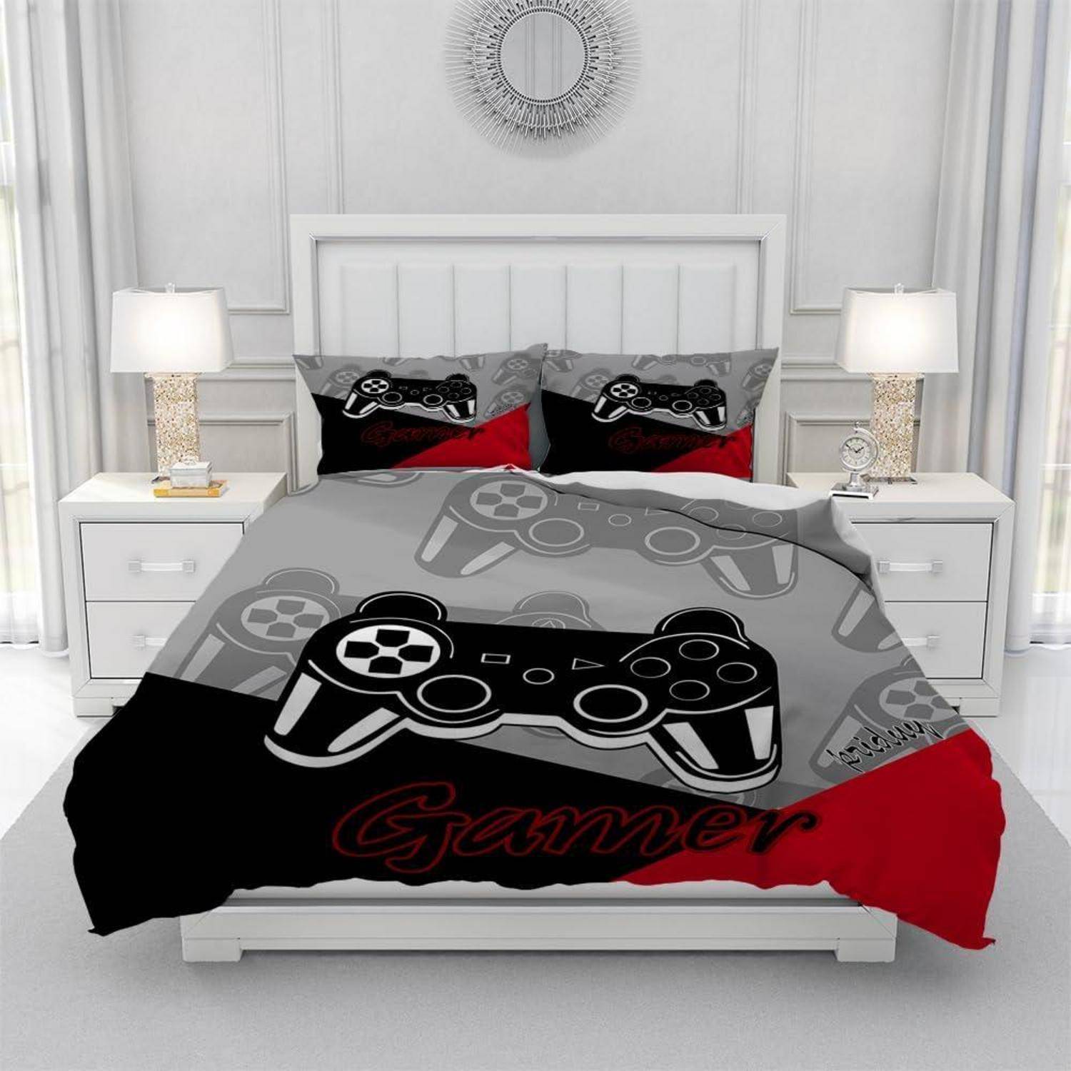 Ein Bett mit grauer, schwarzer und roter Gaming-Bettwäsche mit großen Videospiel-Controller-Grafiken und dem Wort „Gamer" in einem modernen weißen Schlafzimmer.