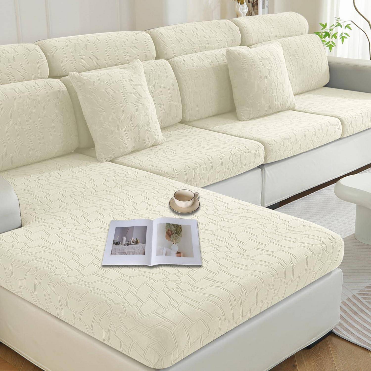 Cremefarbenes Ecksofa mit passendem strukturiertem Sofabezug, Kissen, Zeitschrift und Kaffeetasse in einem hellen Wohnzimmer.