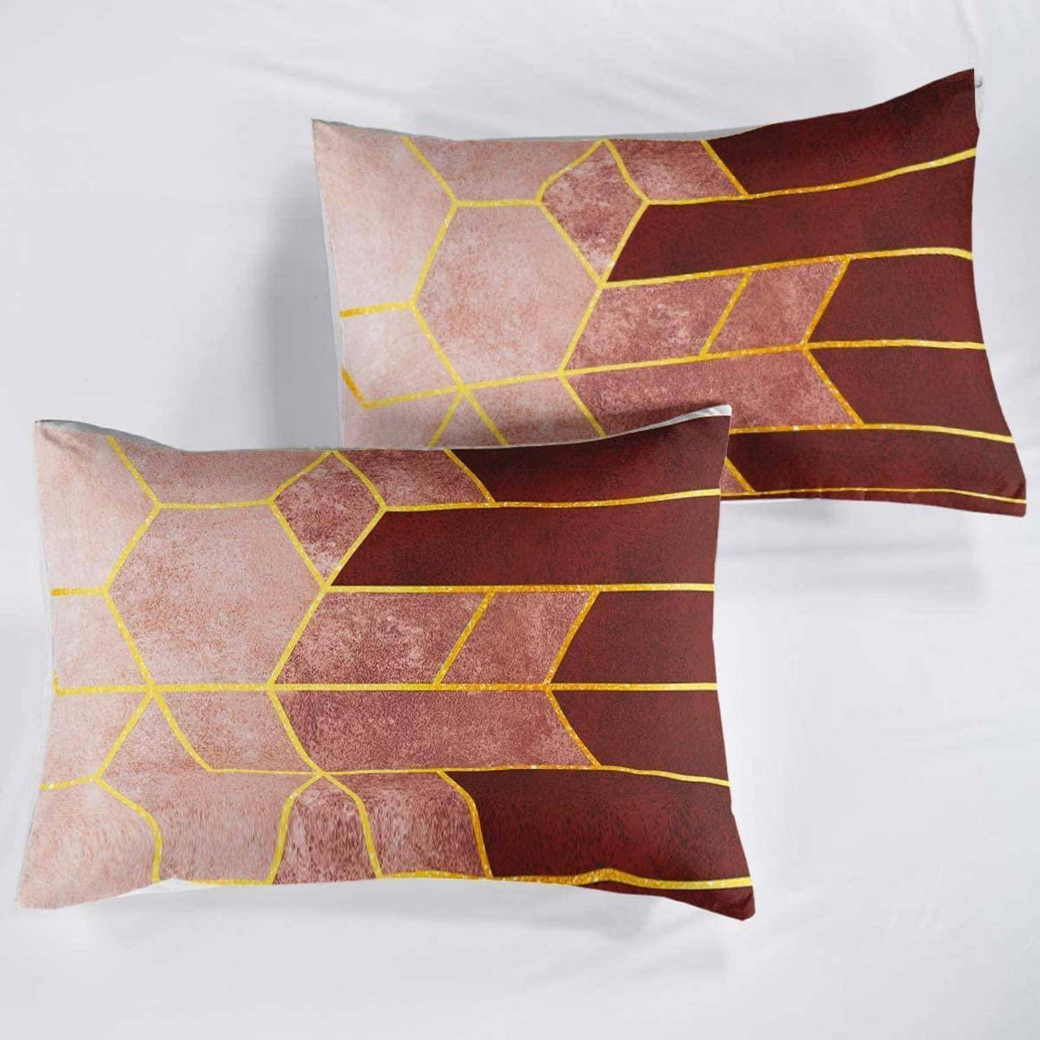 Zwei dekorative rechteckige Kissen mit einem rosa, burgunderroten und goldenen geometrischen Muster auf weißem Hintergrund.
