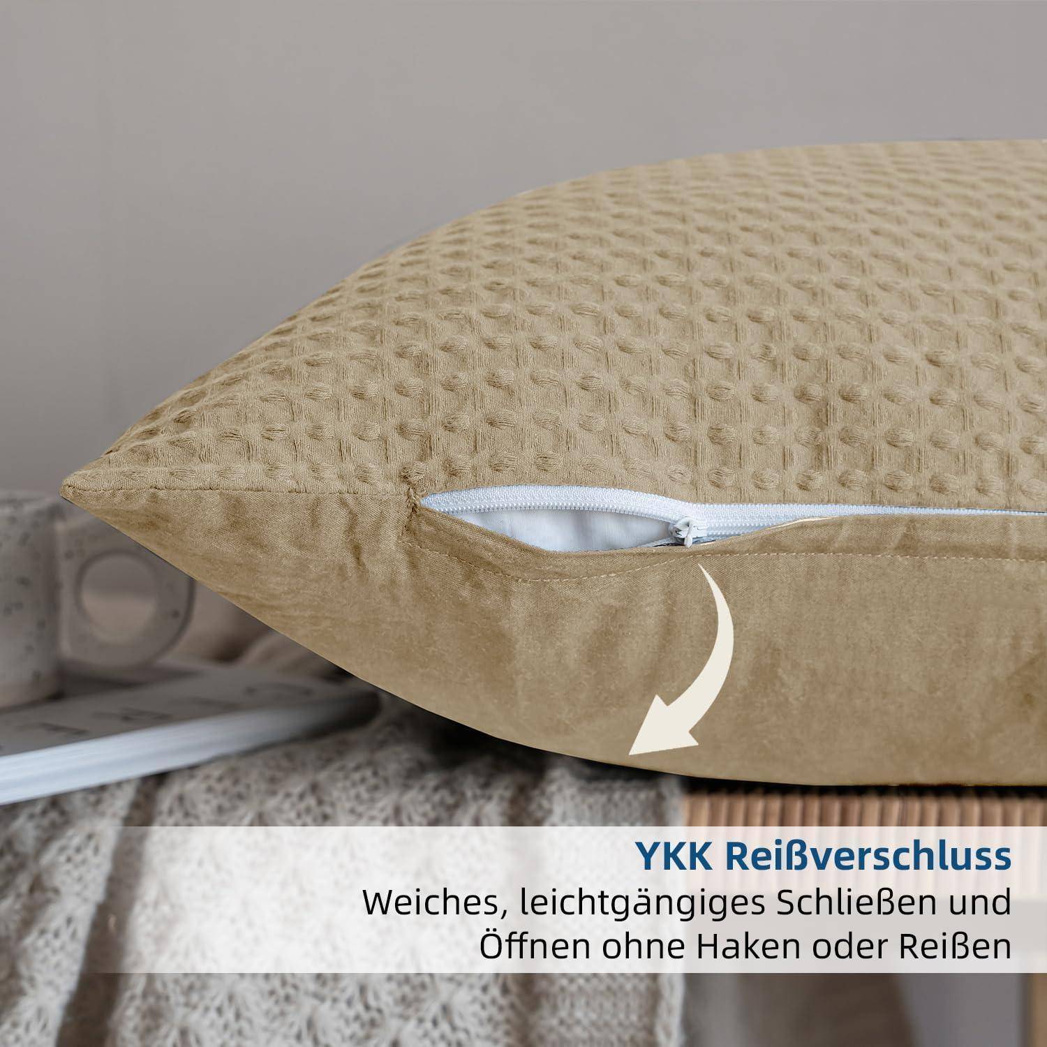 Nahaufnahme eines beigen Kissens mit einem teilweise offenen Reißverschluss, beschriftet mit 'YKK Reißverschluss' und 'Weiches, leichtgängiges Schließen und Öffnen ohne Haken oder Reißen'.