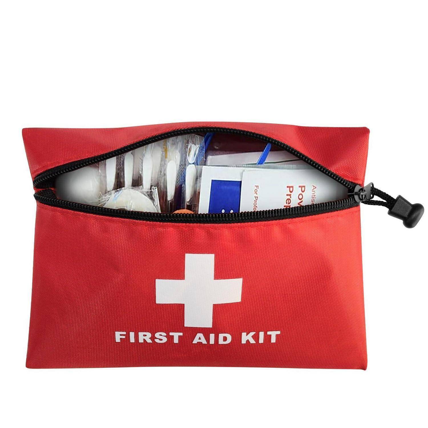 Rote Erste-Hilfe-Tasche mit weißem Kreuz und der Aufschrift „FIRST AID KIT", Reißverschluss offen, um medizinische Utensilien im Inneren zu zeigen.