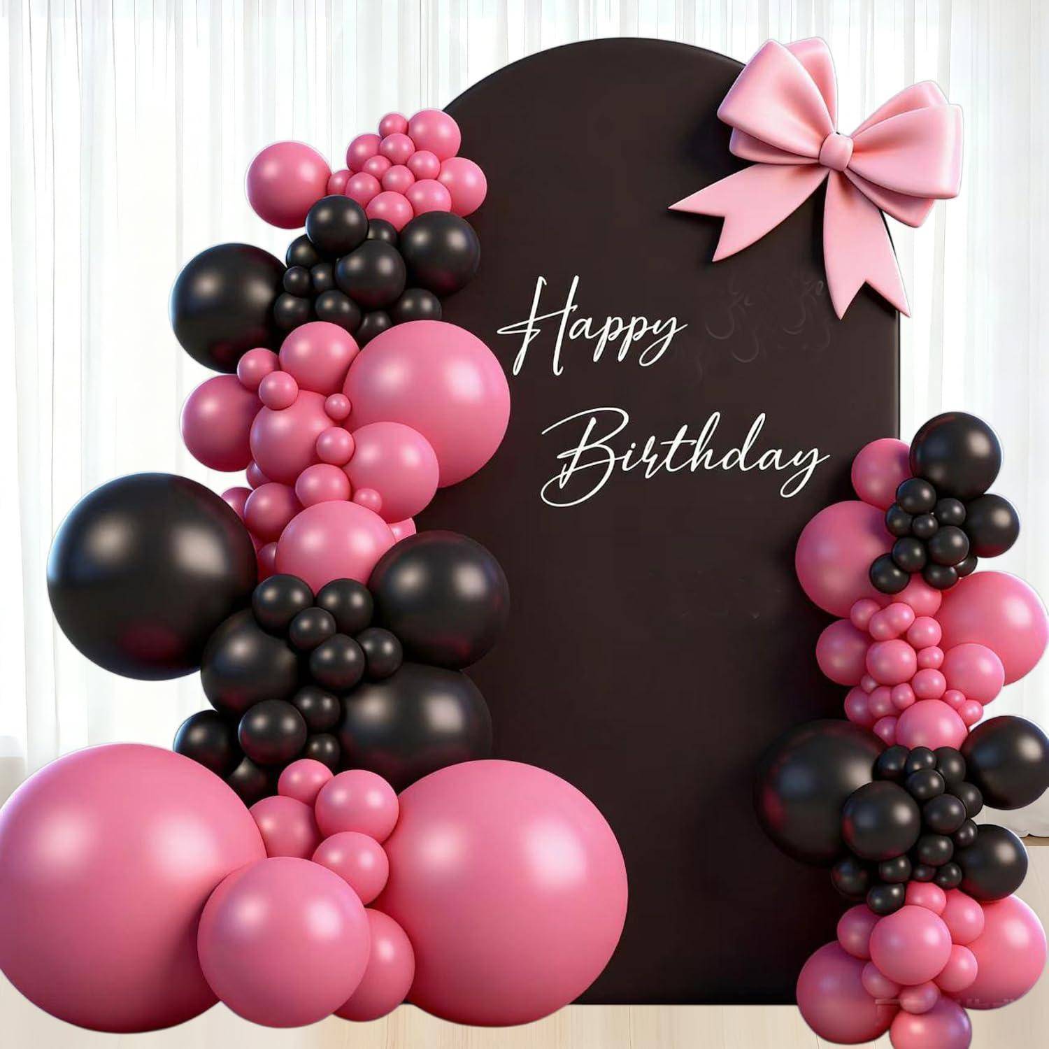 Dunkelbraunes „Happy Birthday"-Schild mit rosa und schwarzen Ballontrauben und einer großen rosa Schleife dekoriert