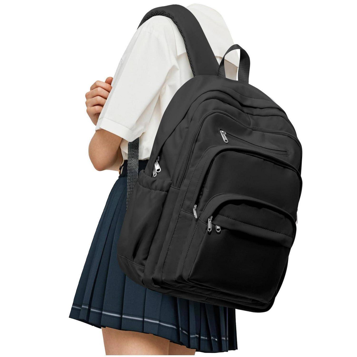 Person trägt einen großen schwarzen Rucksack mit mehreren Reißverschlussfächern und Seitentaschen, von der Seite auf weißem Hintergrund gezeigt.
