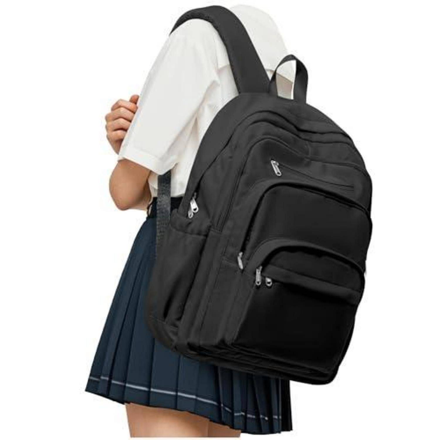 Person mit großem schwarzem Rucksack über einem weißen Hemd und einem dunkelblauen Faltenrock vor neutralem Hintergrund.