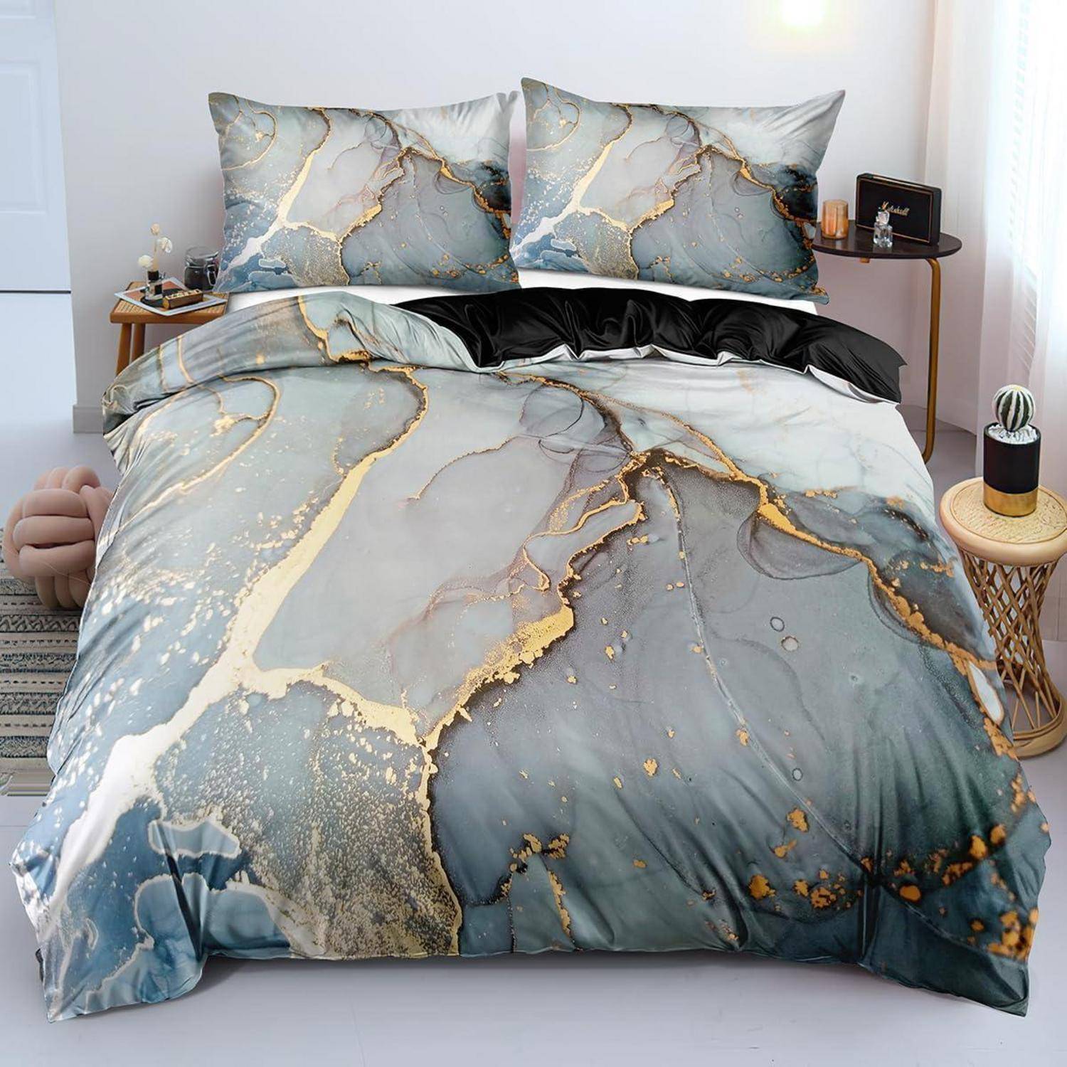 Bett mit blaugrauer Marmormuster-Bettwäsche mit goldfarbenen Akzenten, gezeigt mit passenden Kissen in einem hellen Schlafzimmer.