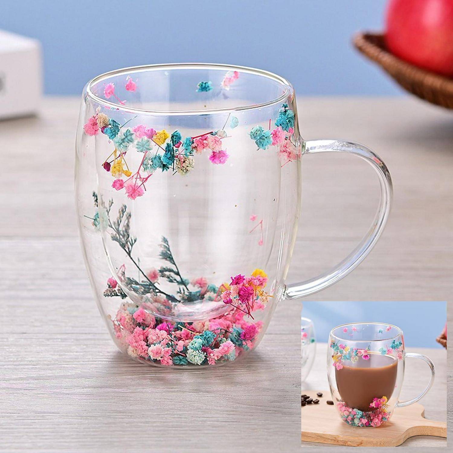 Transparenter Glaskrug mit bunten Blumenmuster verziert, leer auf einem Tisch dargestellt, mit einem kleinen Einschub, das ihn gefüllt mit einem heißen Getränk zeigt.