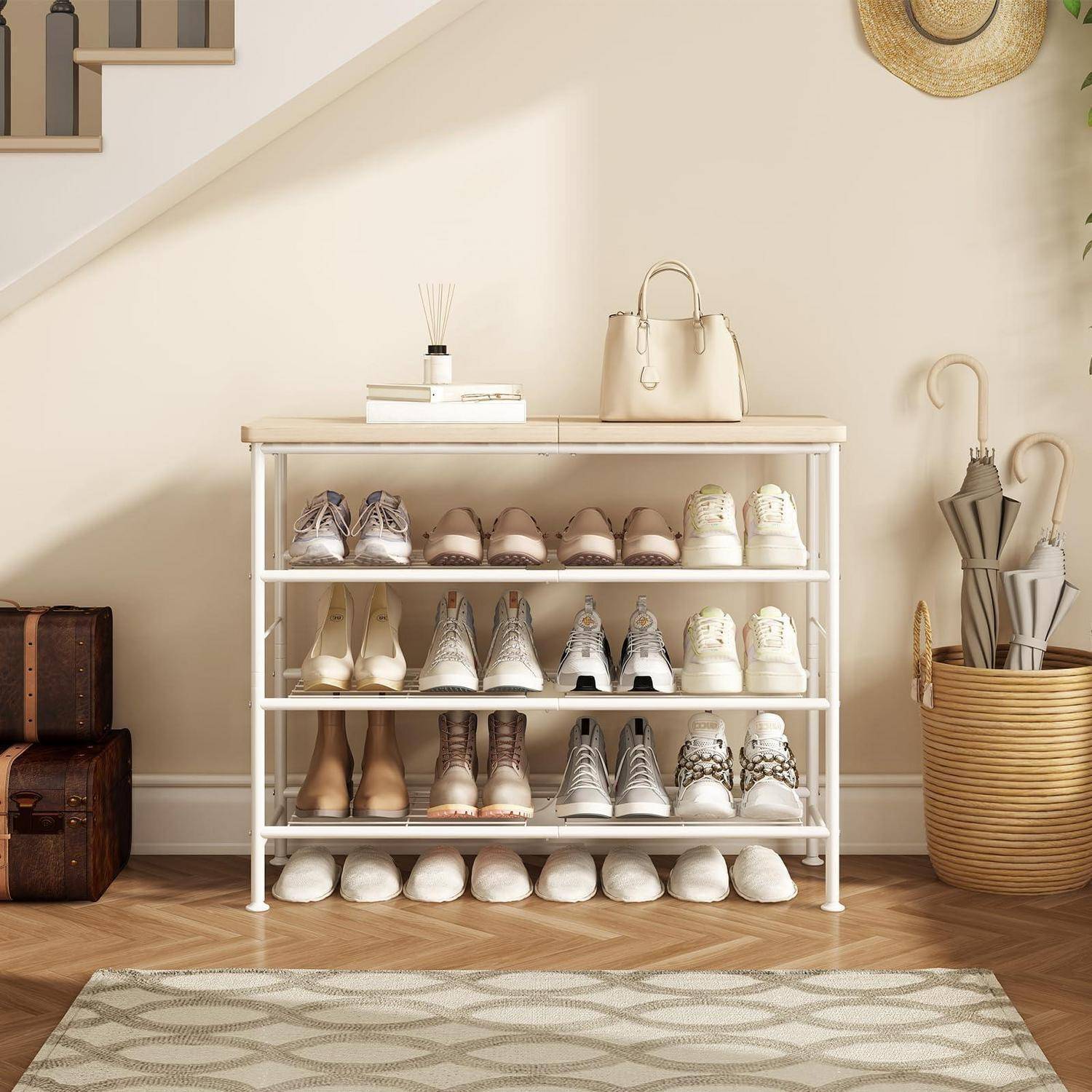 Weißes Schuhregal, das mehrere Paar Schuhe und Stiefel ordentlich in einem minimalistischen Eingangsbereich organisiert, mit einer Handtasche und Dekorationselementen oben.
