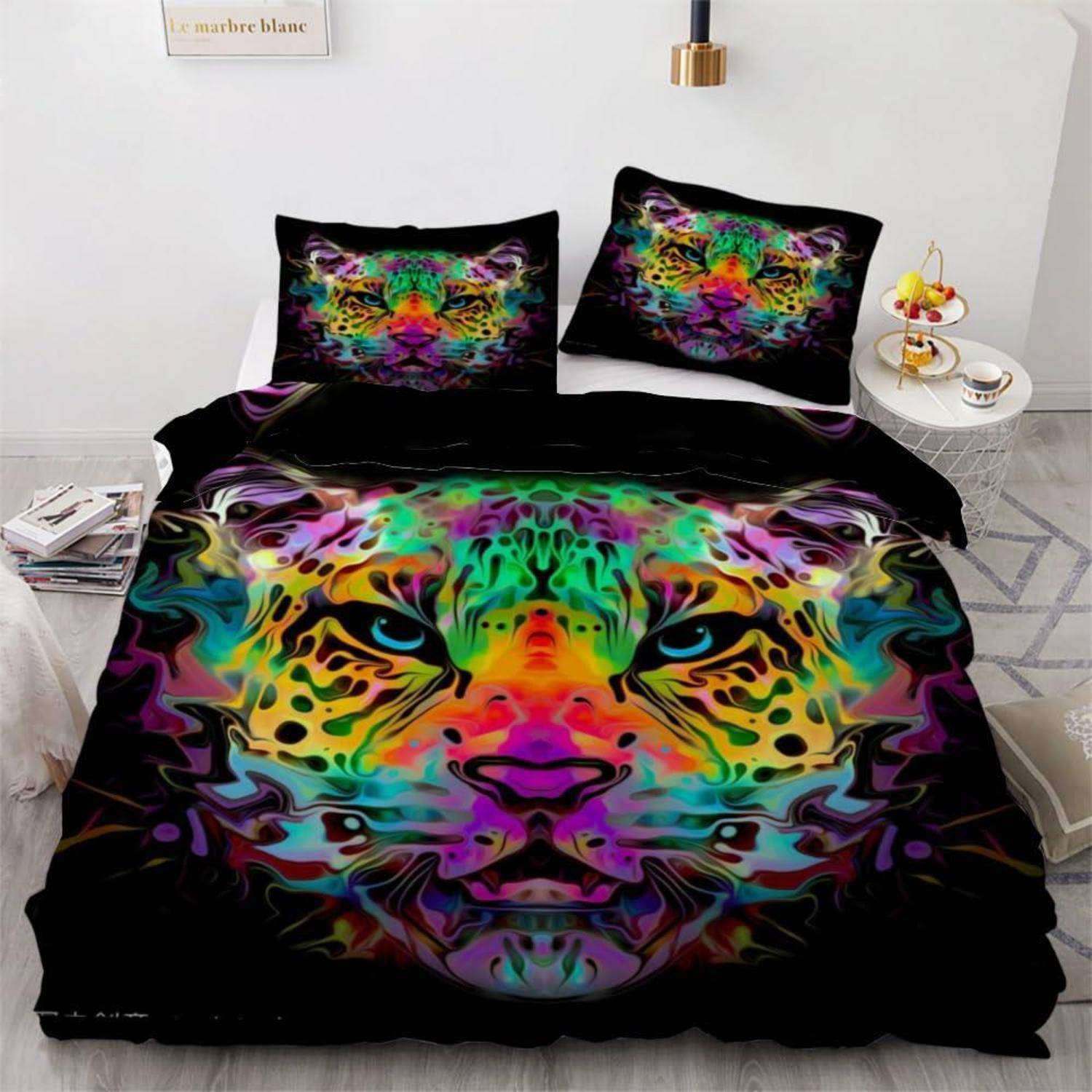 Buntes Tigerkopfmotiv auf einer schwarzen Bettwäsche-Garnitur mit Bettdecke und passenden Kissen in einem Schlafzimmer.