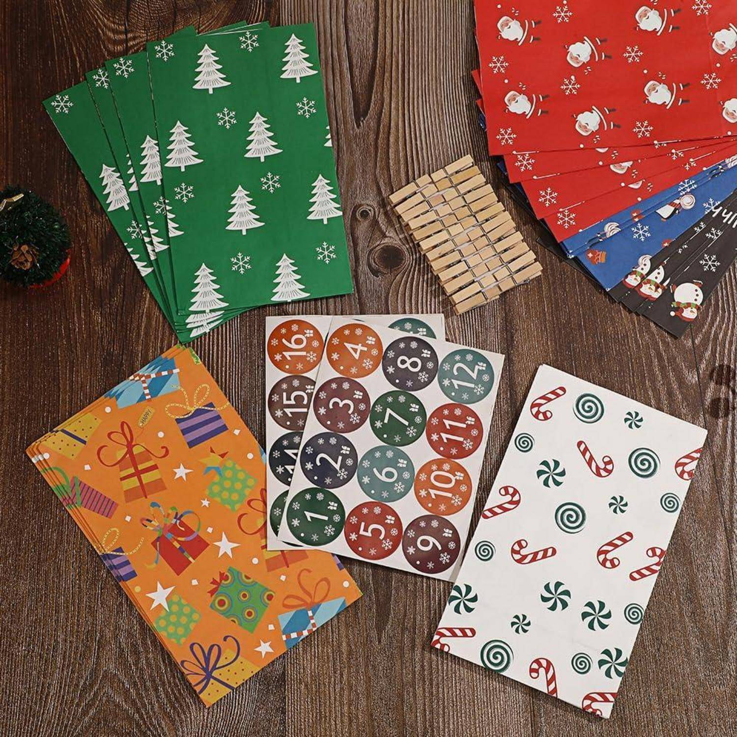Verschiedene Feiertagsgeschenkpapiere mit festlichen Mustern – Bäume, Zuckerstangen, Christbaumkugeln und Geschenke – ausgebreitet auf einem Holztisch.