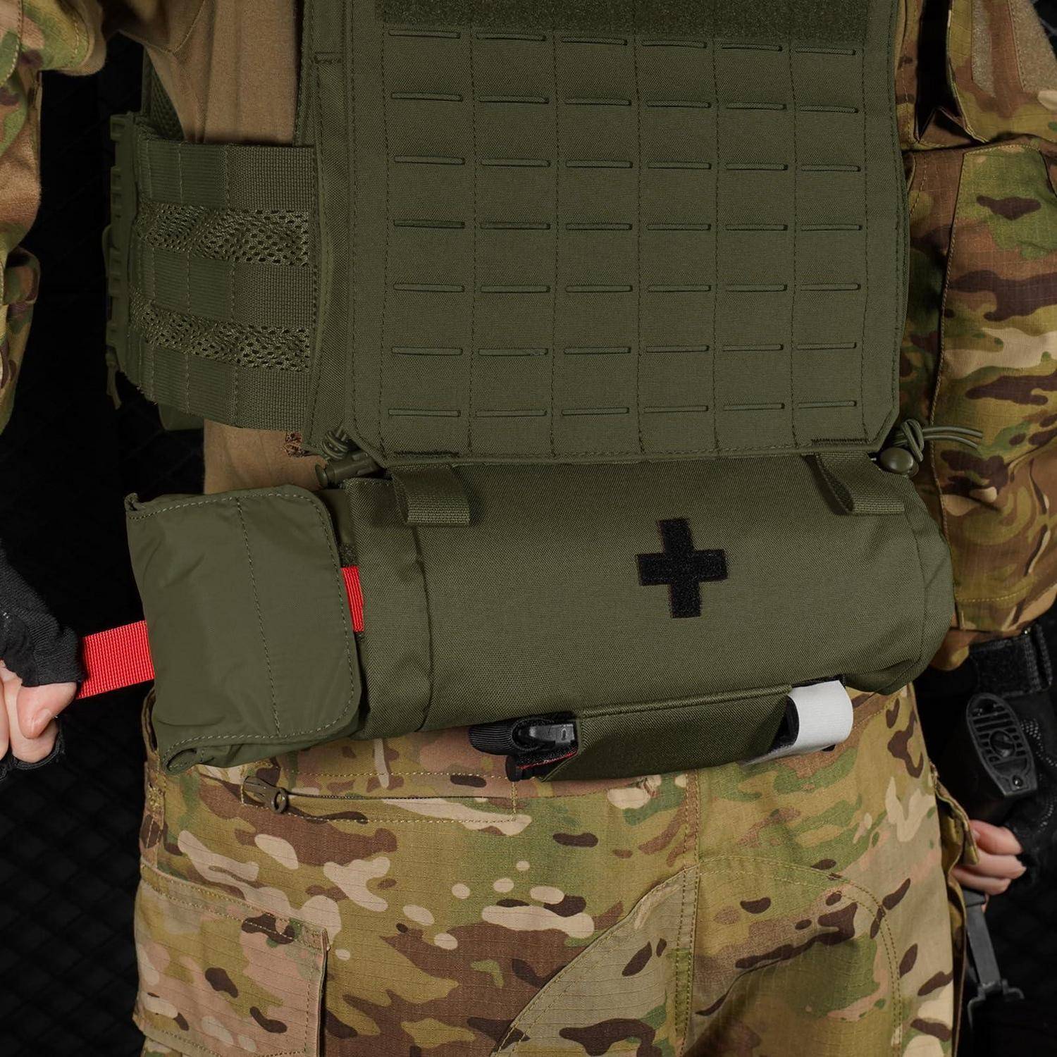 Soldat in Tarnuniform und olivfarbener taktischer Sanitätsweste mit schwarzem Kreuz und Tasche, nahaufnahmeansicht von der Brust bis zur Hüfte.