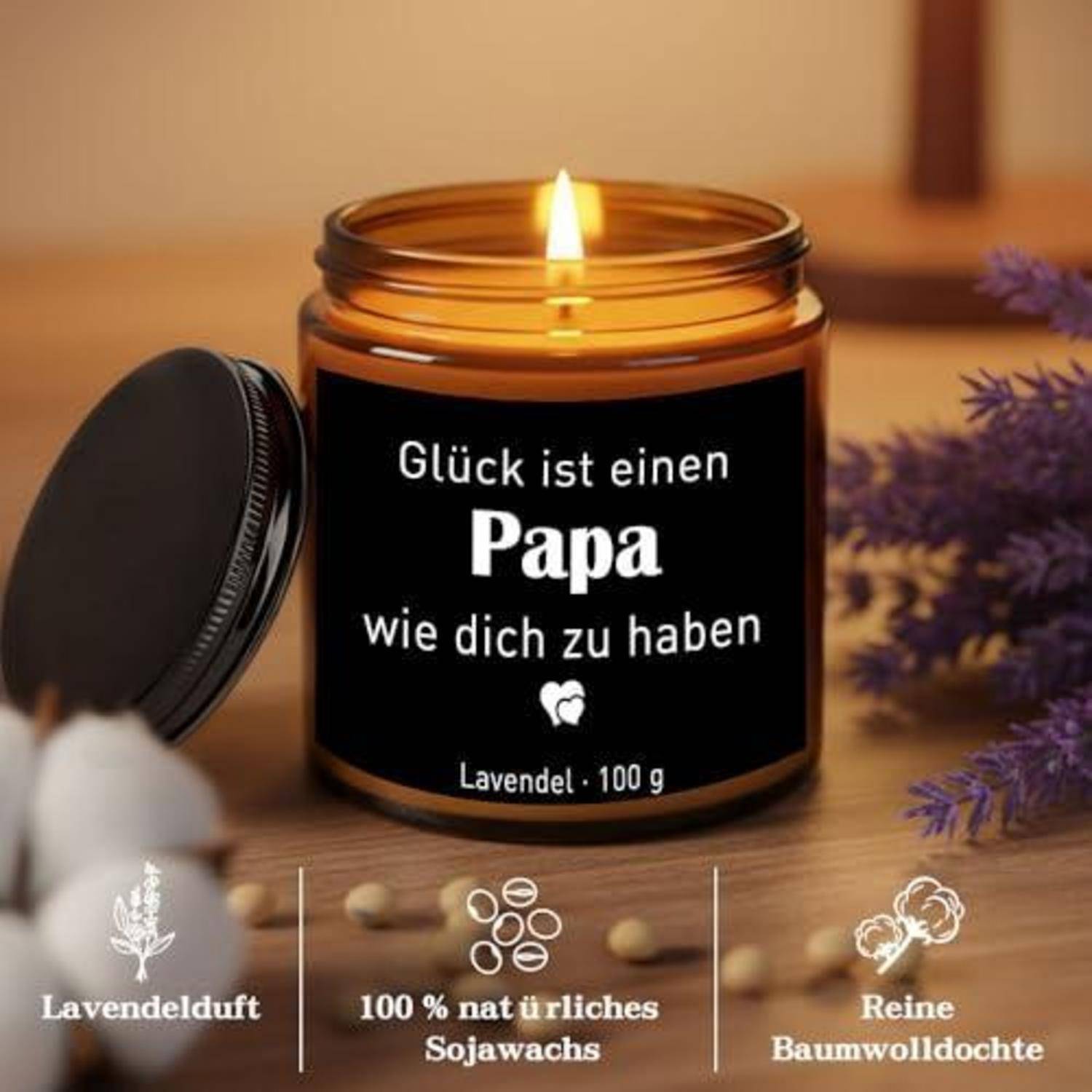 Angezündete Lavendelkerze im Glas mit der Aufschrift "Glück ist einen Papa wie dich zu haben"" und der Beschriftung ""Lavendel · 100 g"" sowie Symbolen für Lavendelduft, 100% natürliches Sojawachs und reiner Baumwollzündstab.