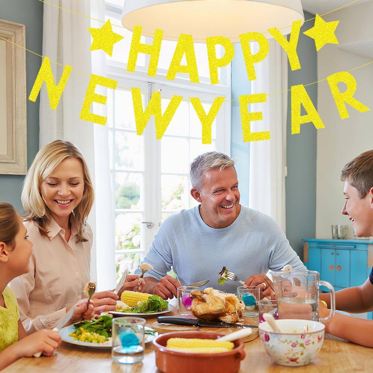 Familie von vier Personen teilt eine Neujahrsmahlzeit an einem Esstisch, mit einem gelben Banner mit der Aufschrift 