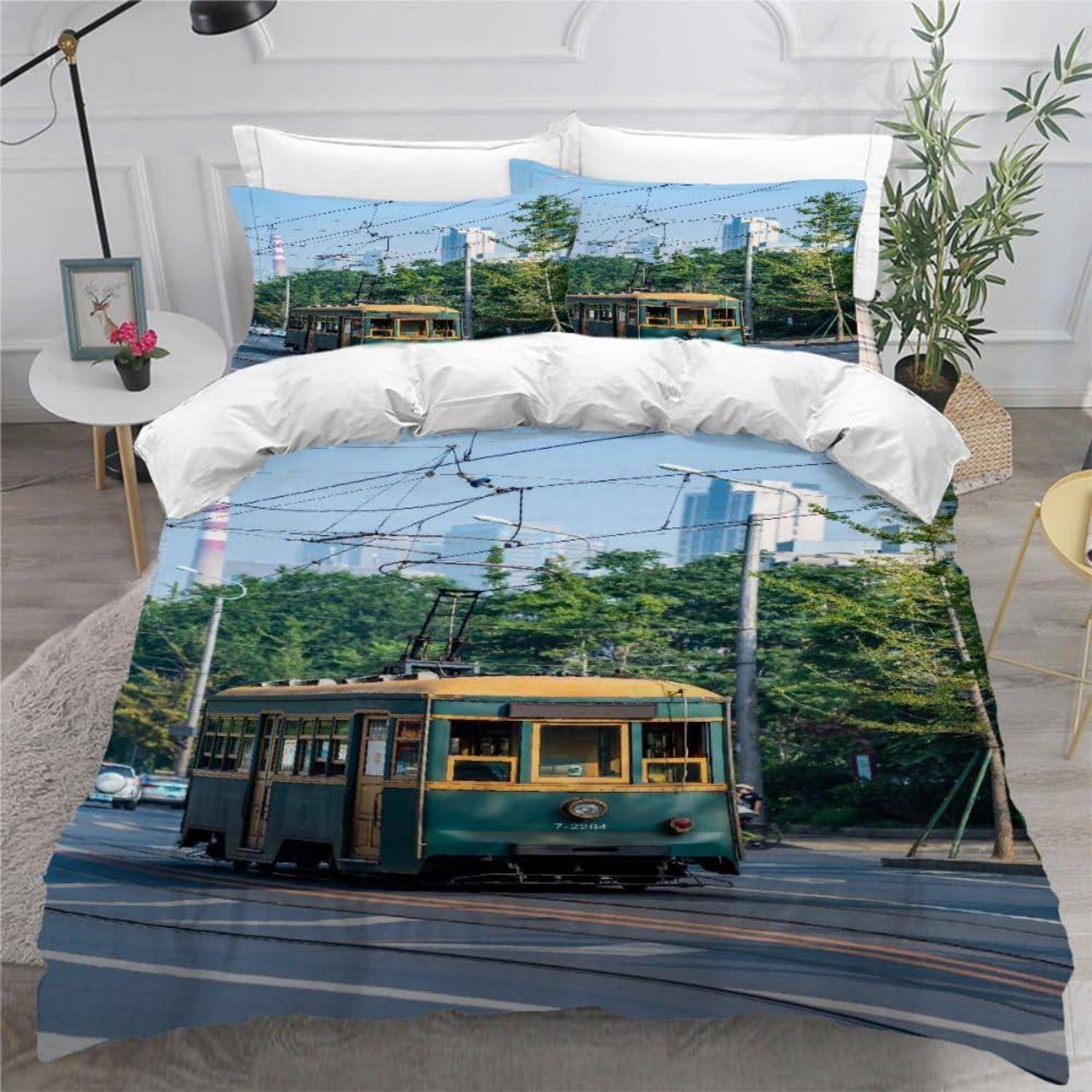 Bett mit Straßenbahn-bedruckter Bettwäsche, die eine vintage grüne Straßenbahn auf Gleisen unter blauem Himmel zeigt, in einem modernen Schlafzimmer.