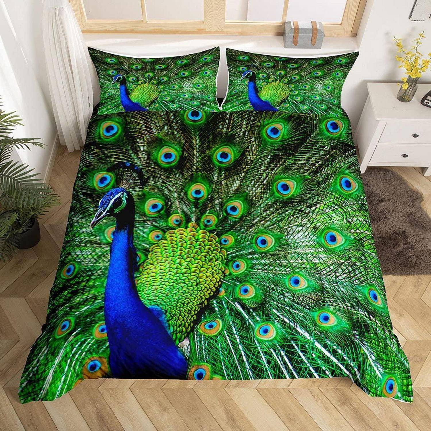 Pfauendruck-Bettwäscheset mit leuchtend grünen und blauen Pfauenfedern und einem großen Pfauenbild auf der Bettdecke und den Kissen in einem hellen Schlafzimmer.
