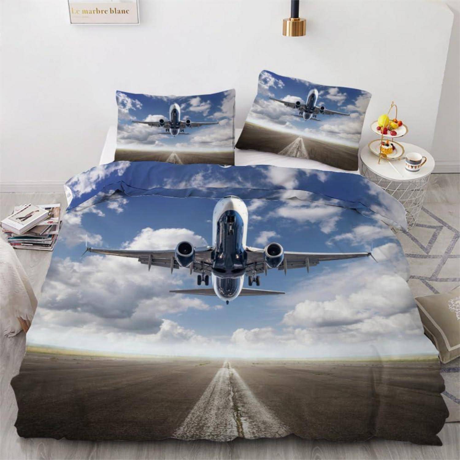 Ein Bettset mit einem Flugzeug, das auf der Landebahn auf den Betrachter zufliegt, gedruckt auf der Bettdecke und den Kissenbezügen in einem hellen Schlafzimmer.