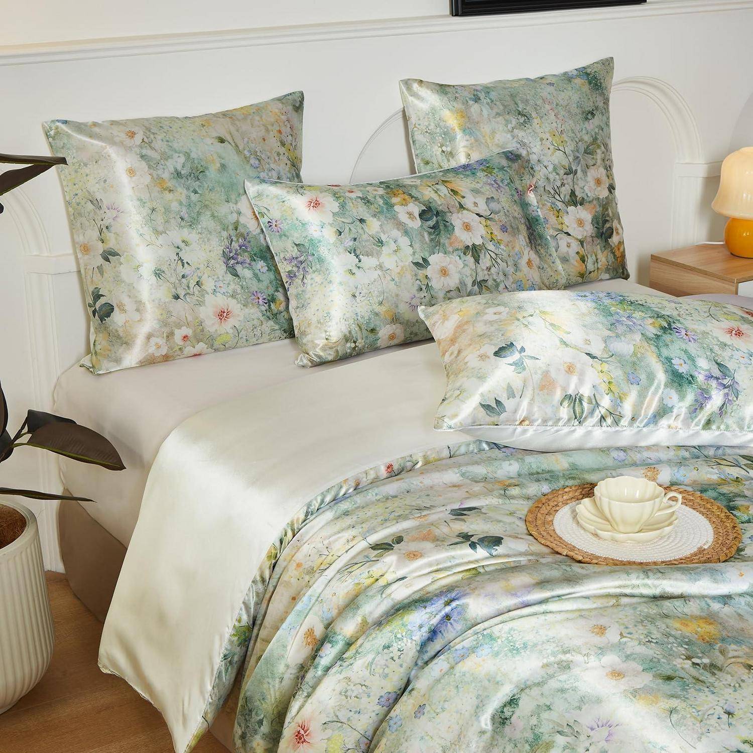 Blumenmuster-Bettwäscheset auf einem ordentlich gemachten Bett, mit passenden Kissen und einer bedruckten Decke in weichen Pastellfarben.
