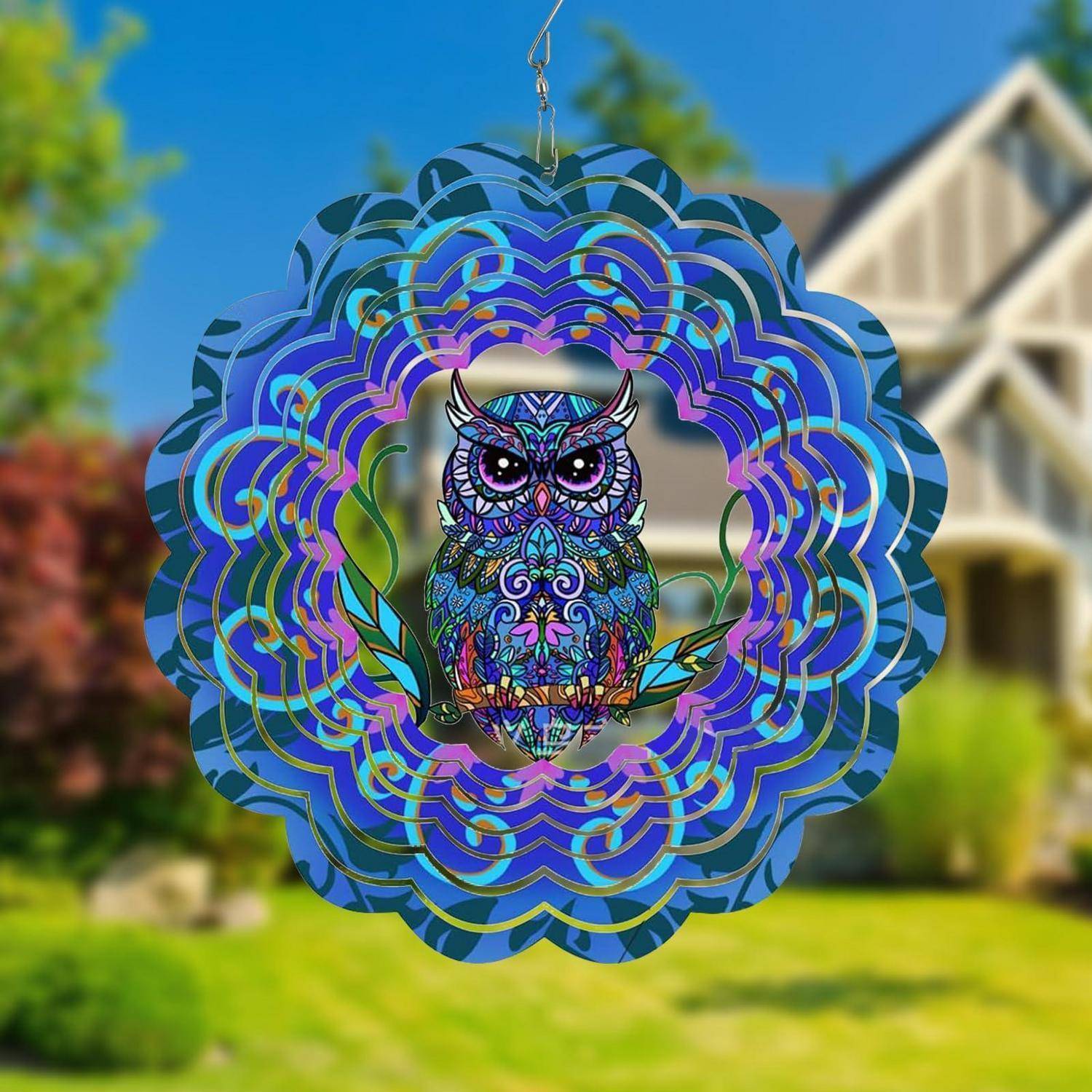 Buntes, eulenthematisches hängendes Sonnenfänger mit geschichteten kreisförmigen blau- und violetten Mustern, dargestellt im Freien vor einem Haus und Rasen.