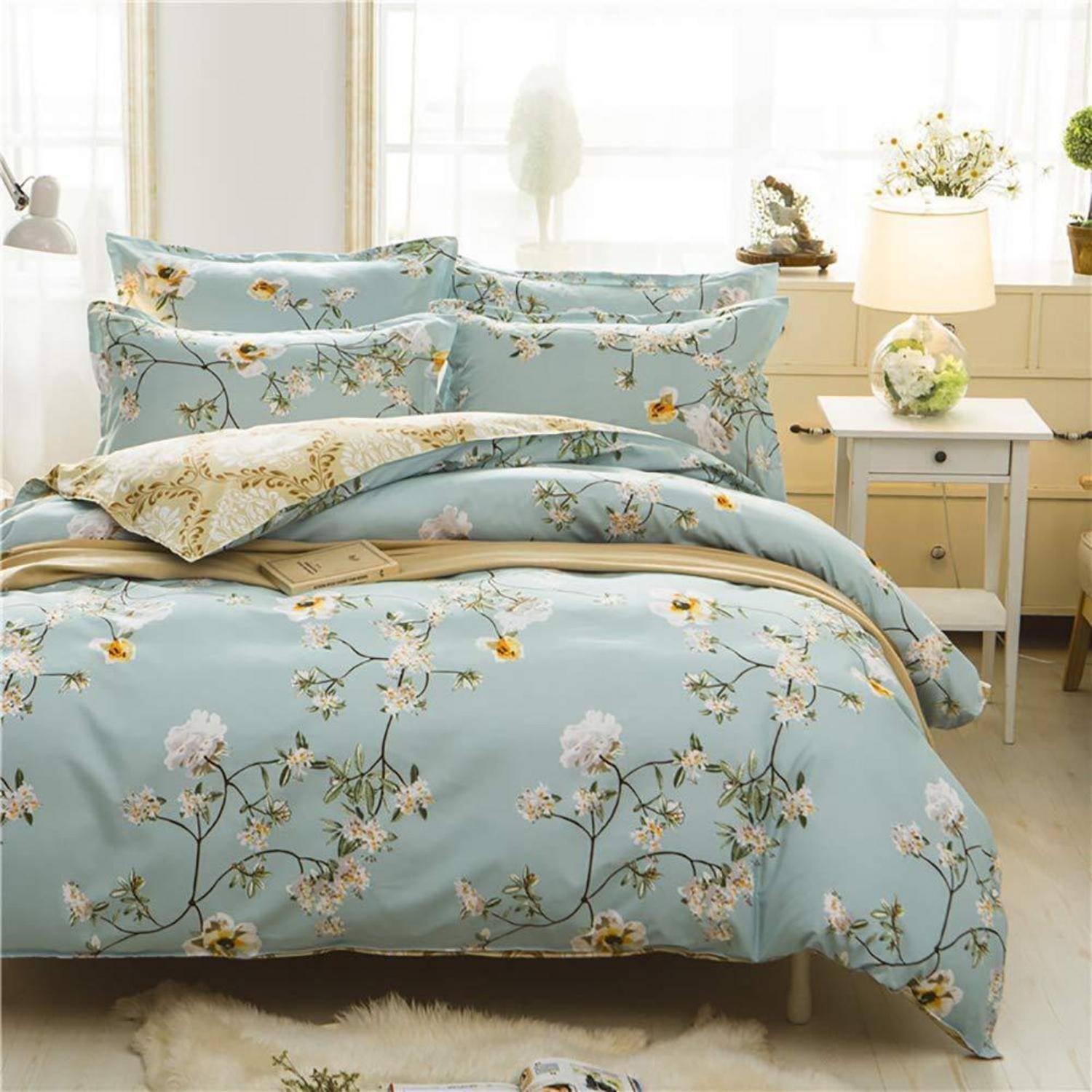 Zartes blaues Blumenbettwäsche-Set auf einem ordentlich gemachten Bett in einem hellen Schlafzimmer, mit passenden Kissen und Bettdeckenbezug