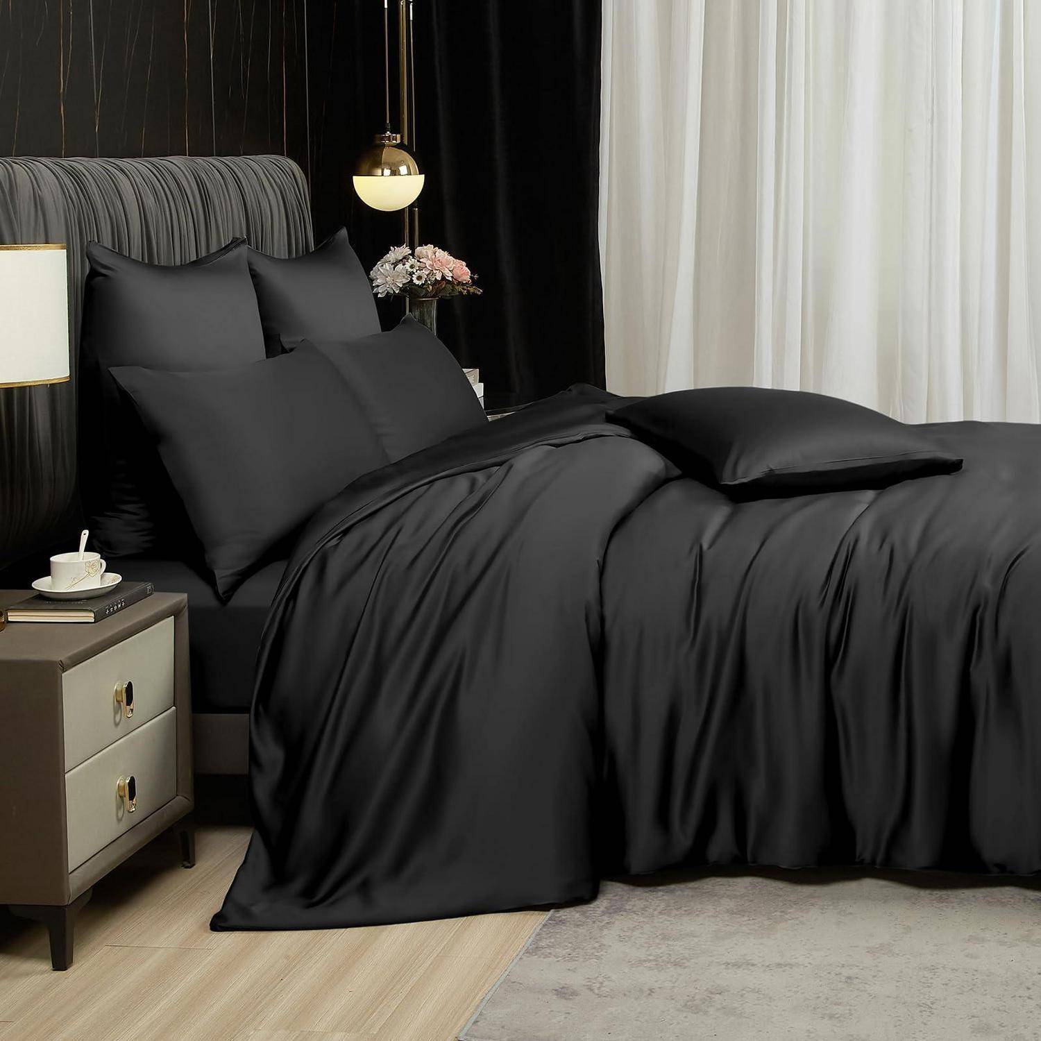 Ein sorgfältig gemachtes Bett mit schwarzer Bettwäsche und Kissen neben einem Nachttisch mit einer Lampe und einer Tasse in einem modernen Schlafzimmer mit dunklen und durchsichtigen Vorhängen.