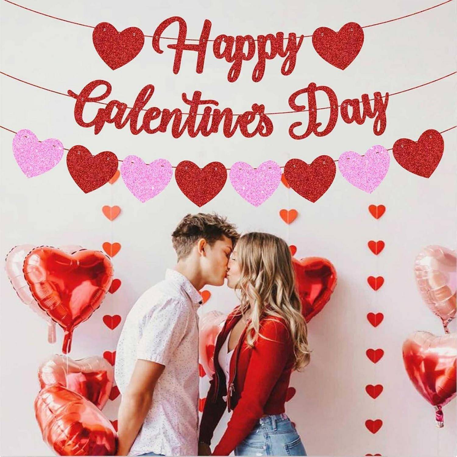 Ein Paar, das unter Herzdekorationen mit der Aufschrift „Happy Galentines Day