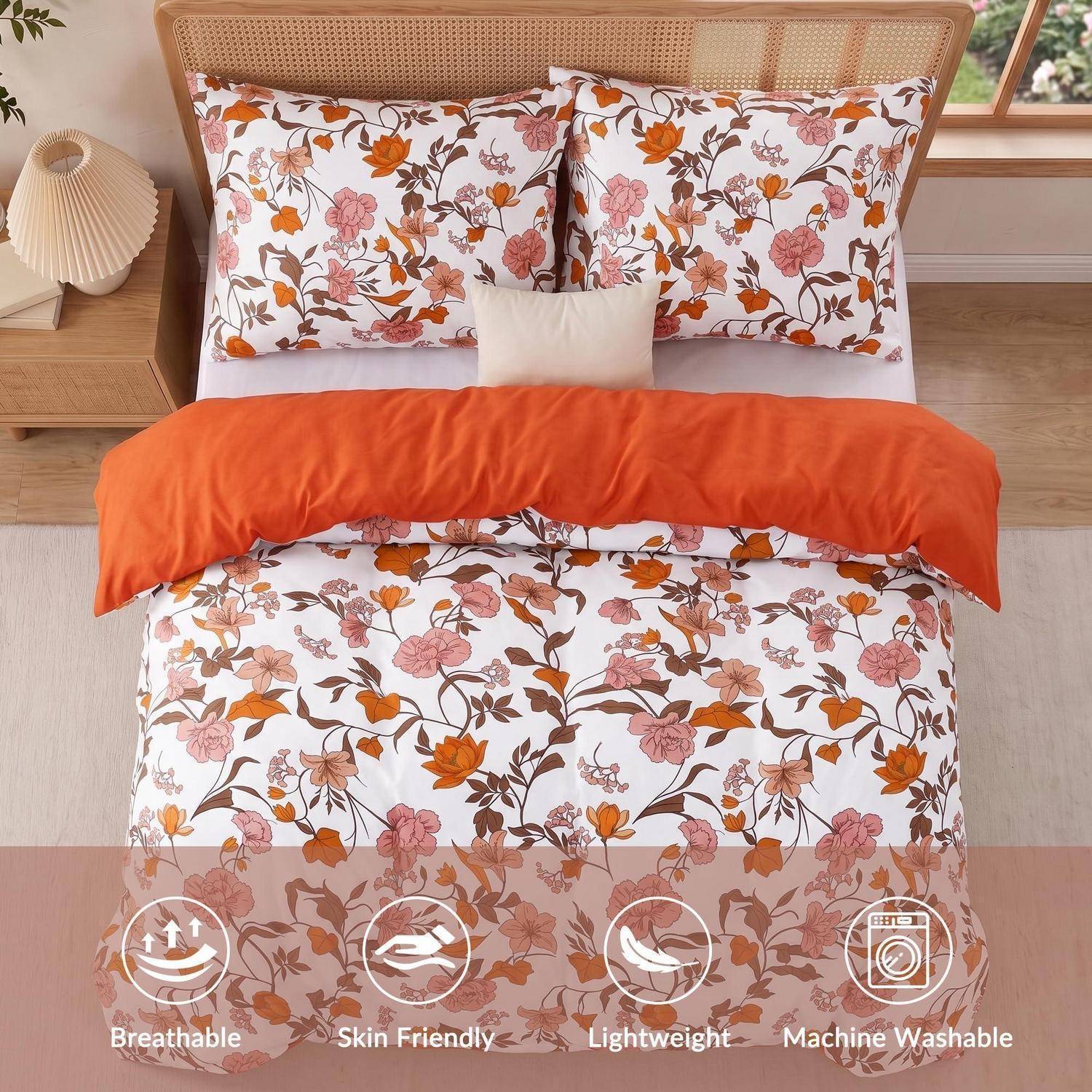 Blumenmusterbettwäsche auf einem ordentlich gemachten Bett mit orangener Decke und weißem Kissen, gekennzeichnet als atmungsaktiv, hautfreundlich, leicht, maschinenwaschbar.