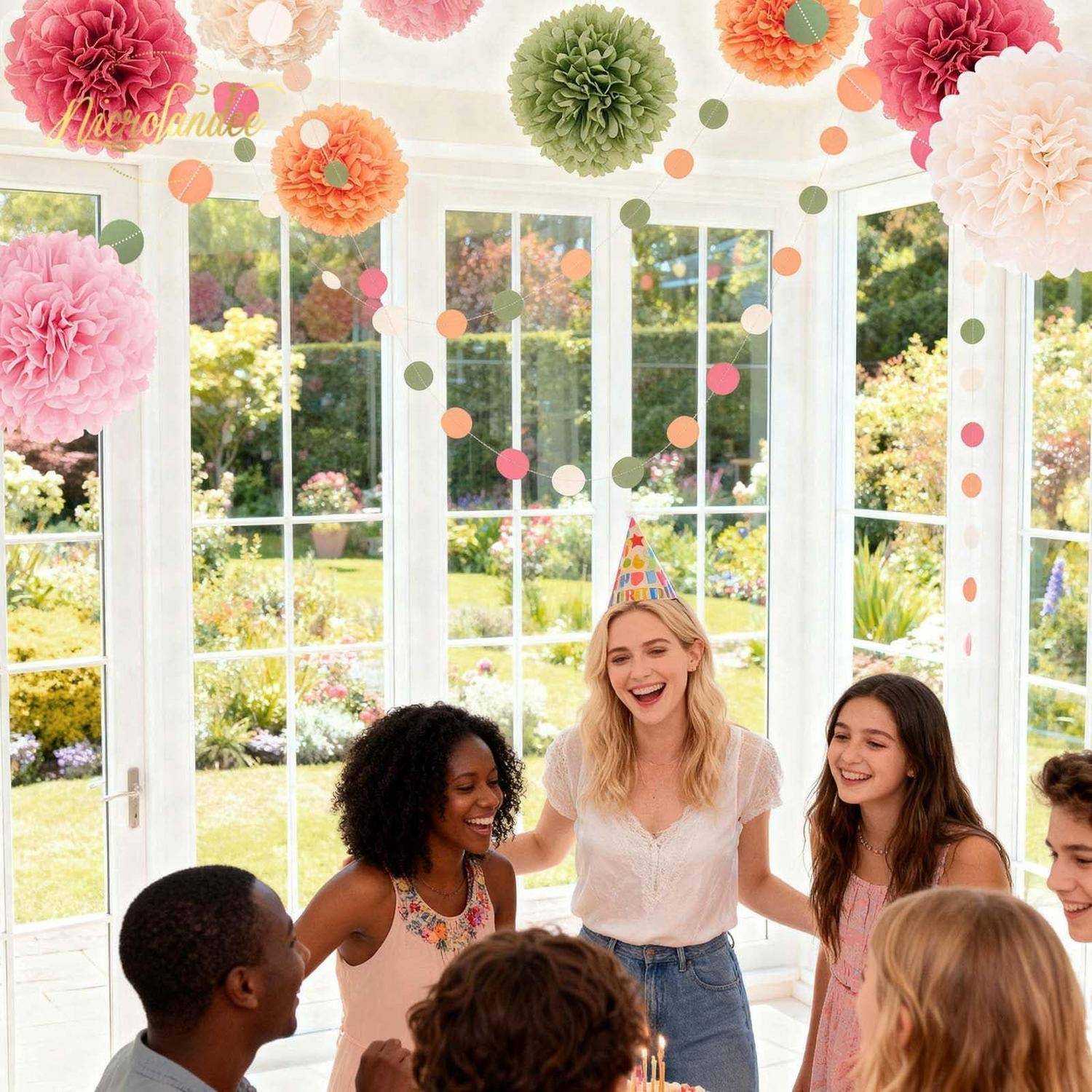 Frauen und Männer auf einer Geburtstagsfeier in einem hellen gläsernen Wintergarten, versammelt um eine lächelnde Frau mit Partyhut unter bunten Papierdekoration.
