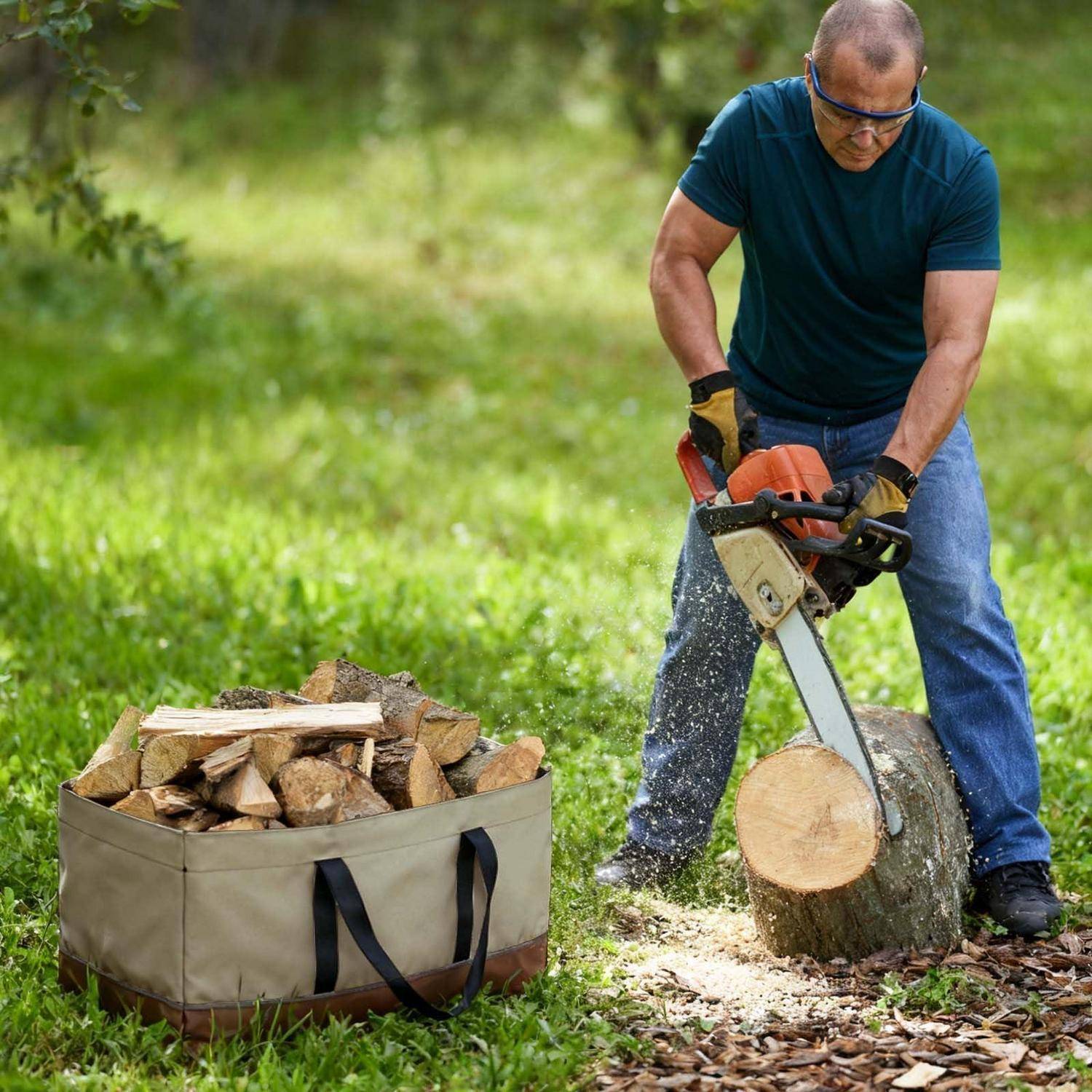 Ein Mann, der mit einer Kettensäge einen Baumstamm im Freien durchtrennt, mit einem Sack gehacktem Brennholz neben ihm auf dem Gras.