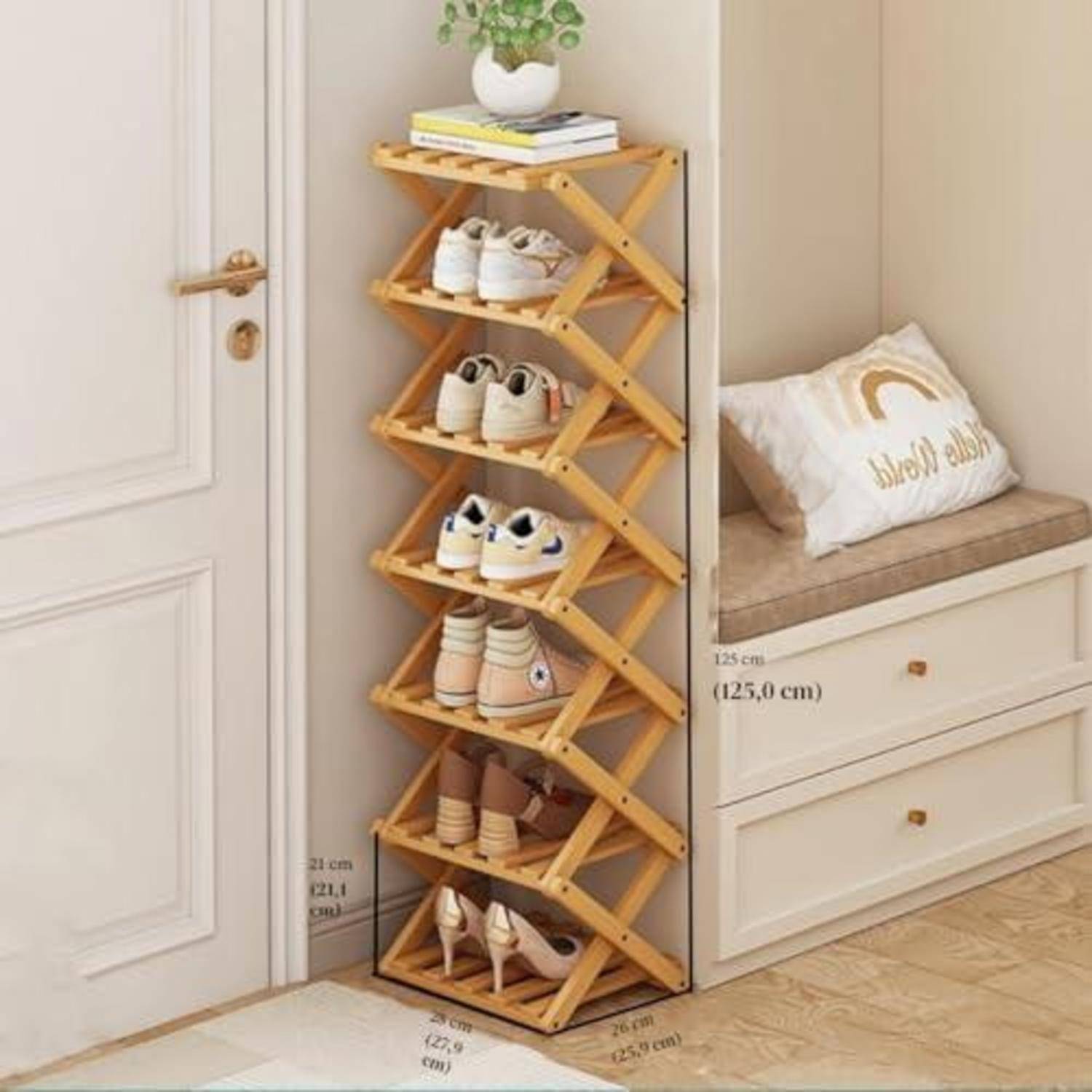Klappbares Schuhgestell aus Holz in einer Ecke, das mehrere Schuhpaare hält und oben mit Büchern und einer Pflanze neben eingebauten Schubladen und einer Bank belegt ist.