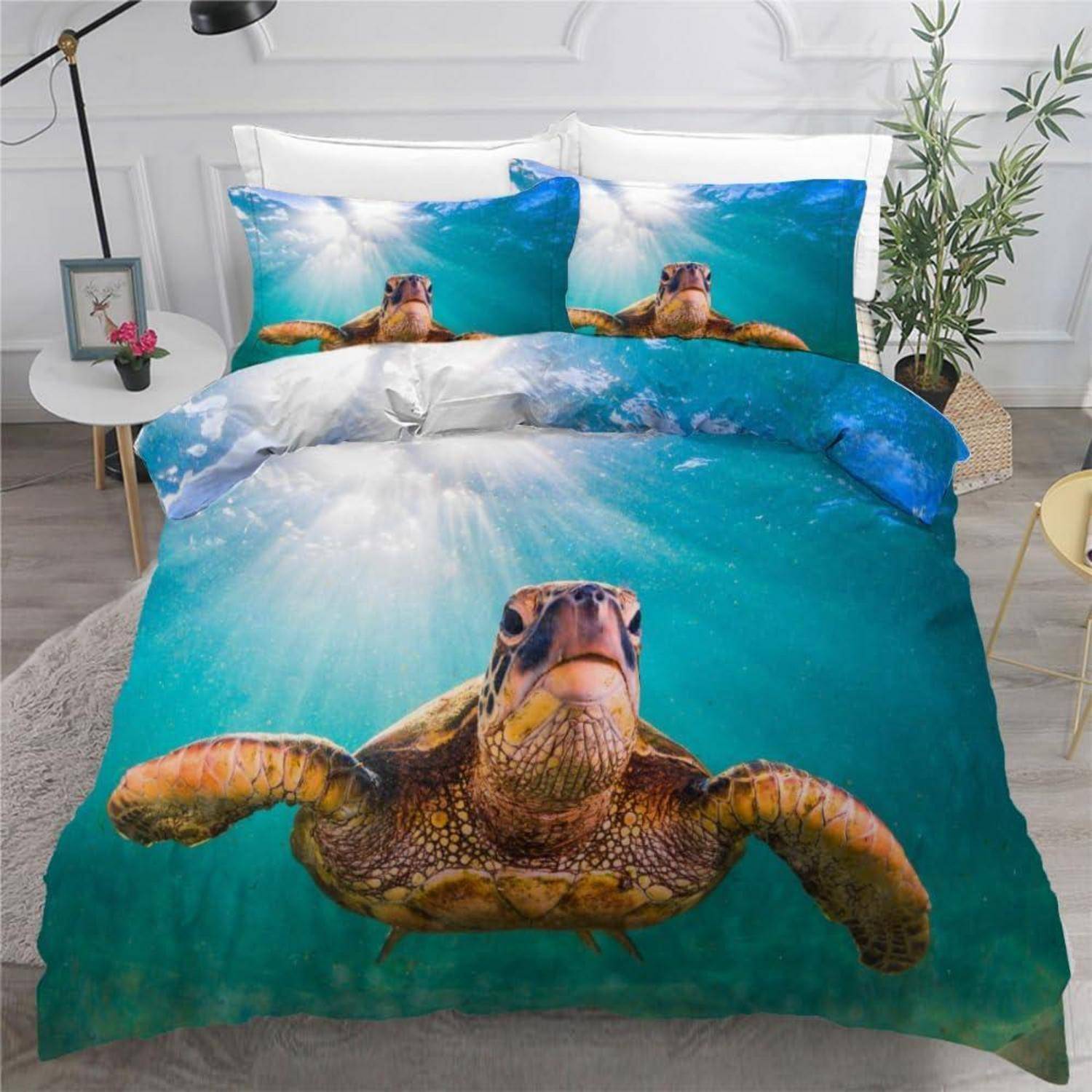 Bettwasche-Set mit Schildkröten-Motiv mit einem großen Meeresschildkröten-Druck auf der Bettdecke und passenden Kissenbezügen in einem hellen Schlafzimmer.