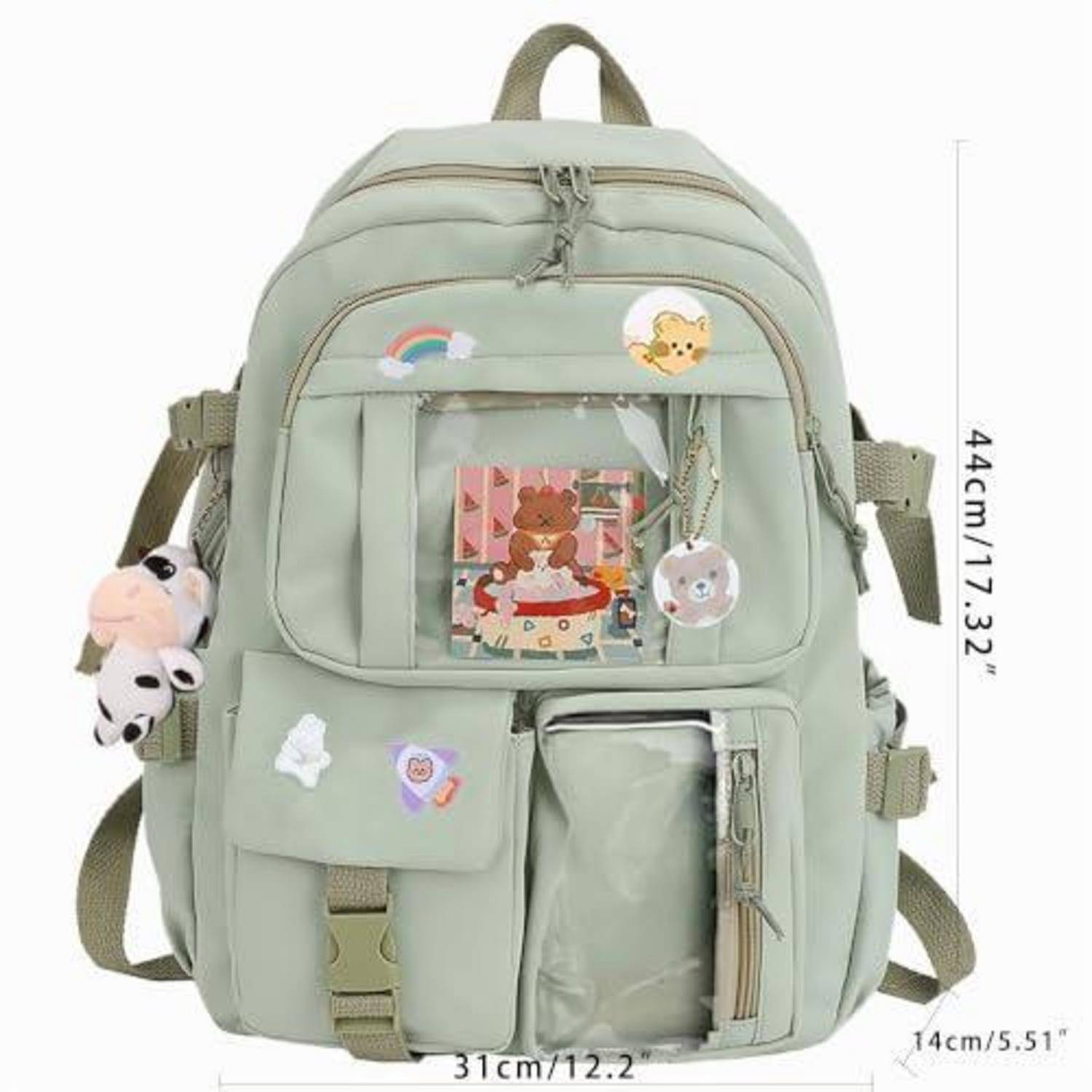 Hellgrüner Rucksack mit mehreren Reißverschlusstaschen, kleinem Plüsch-Anhänger und Aufnähern; mit einer Höhe von 44 cm und einer Breite von 31 cm gekennzeichnet.