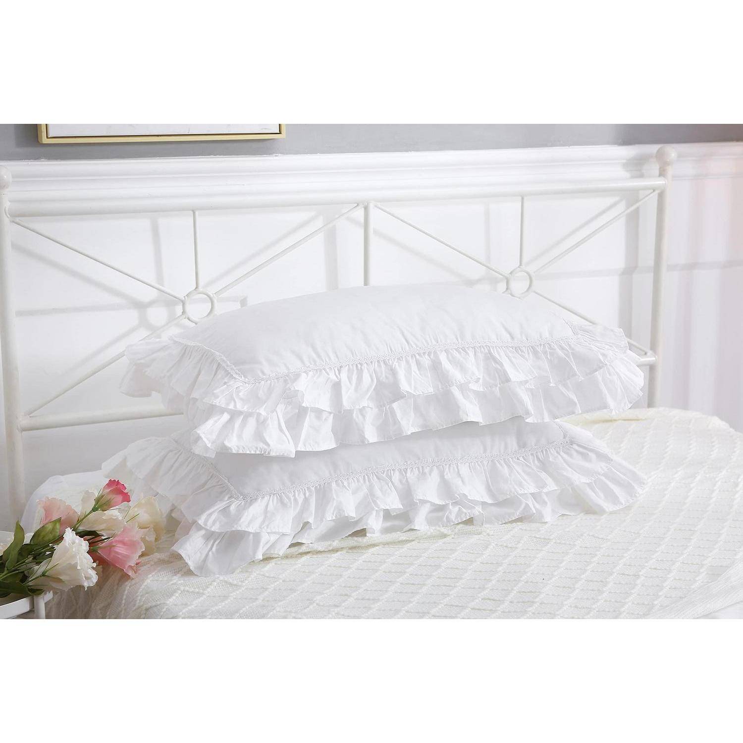 Weißes gerüschtes Kissen auf einem weißen Bett mit metallischem Kopfteil, das einen weichen, dekorativen Schlafzimmer-Look verleiht.