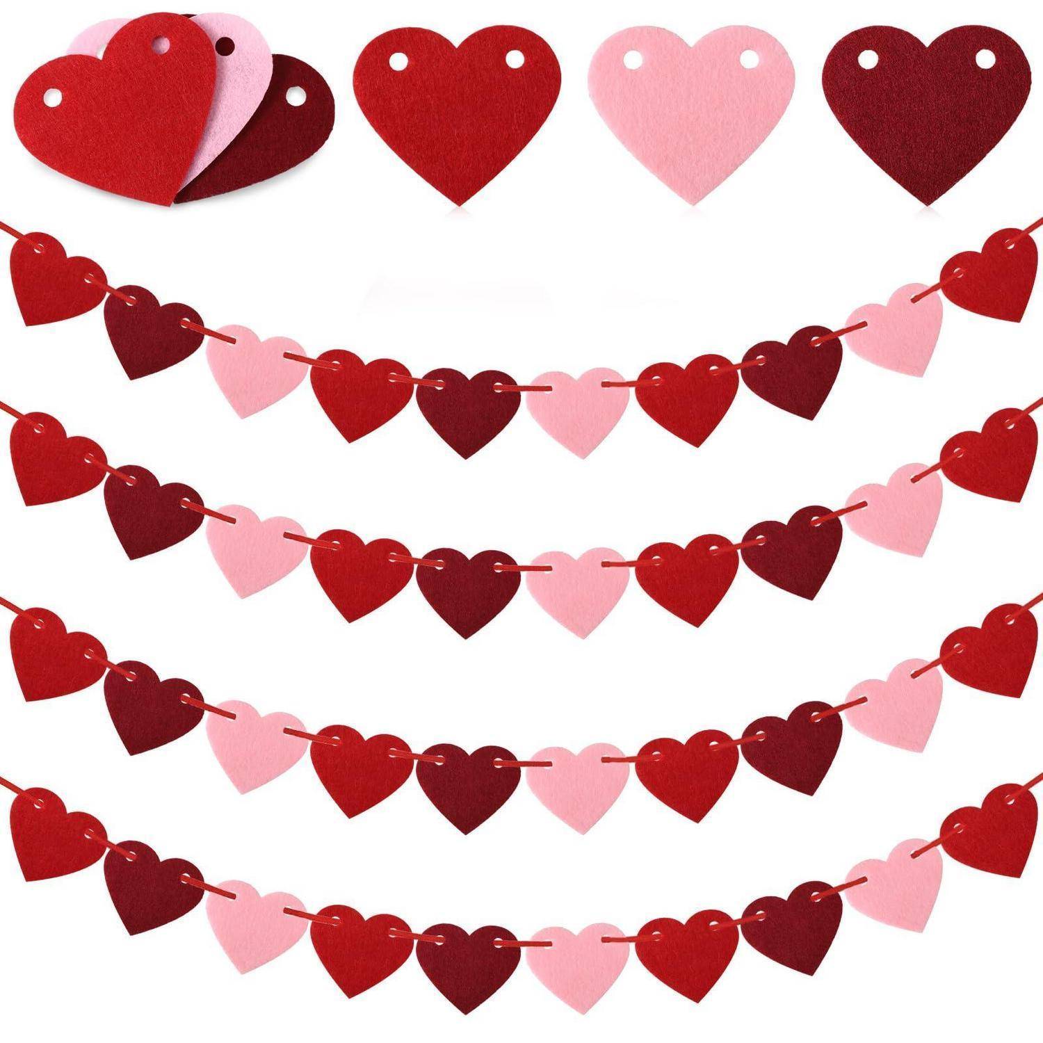 Valentinstagsthema-Papierherzen in Rot, Rosa und Burgund, die als Girlanden auf weißem Hintergrund angeordnet sind, mit zusätzlichen losen Herzen oben.