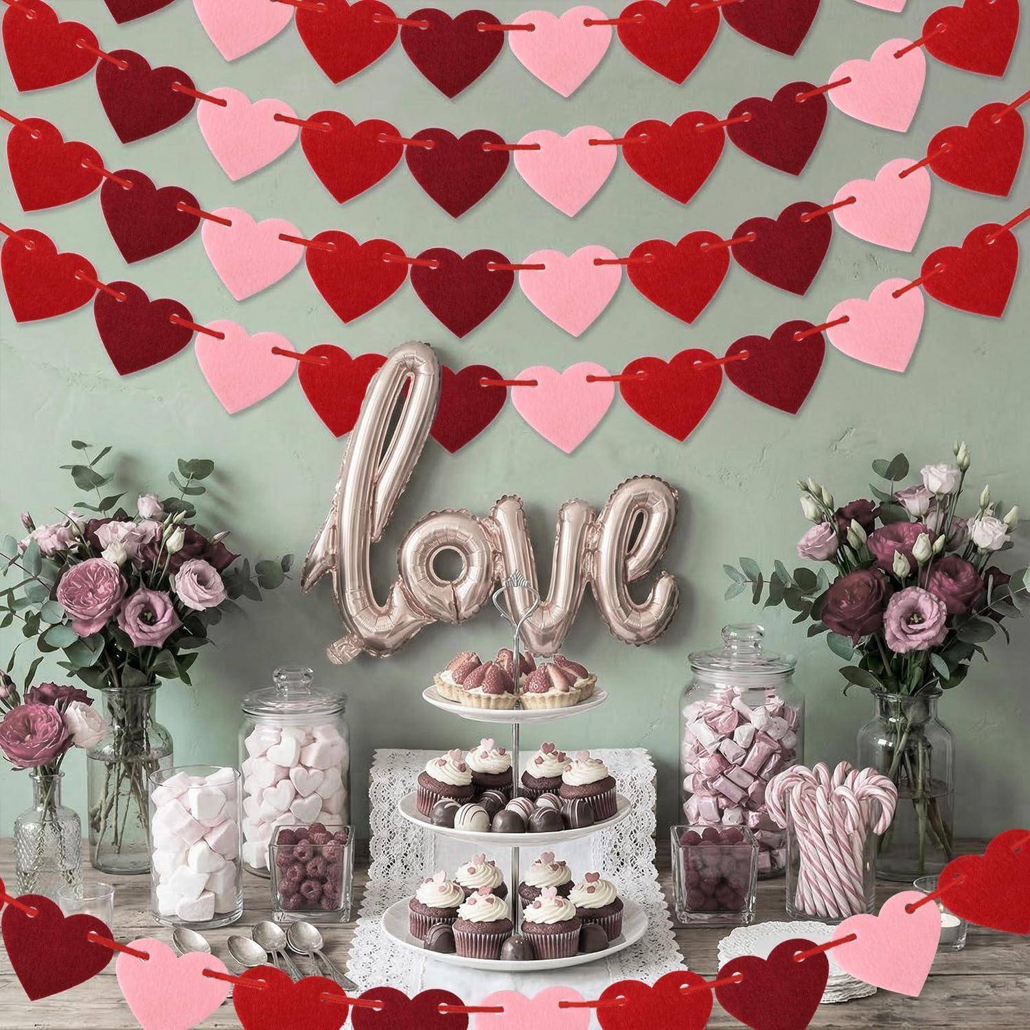 Valentinstag-Dessert-Display mit „Liebe"-Luftballon, Herzgirlanden, Cupcakes, Süßigkeiten, Blumen und Tischaufbau für eine romantische Feier.