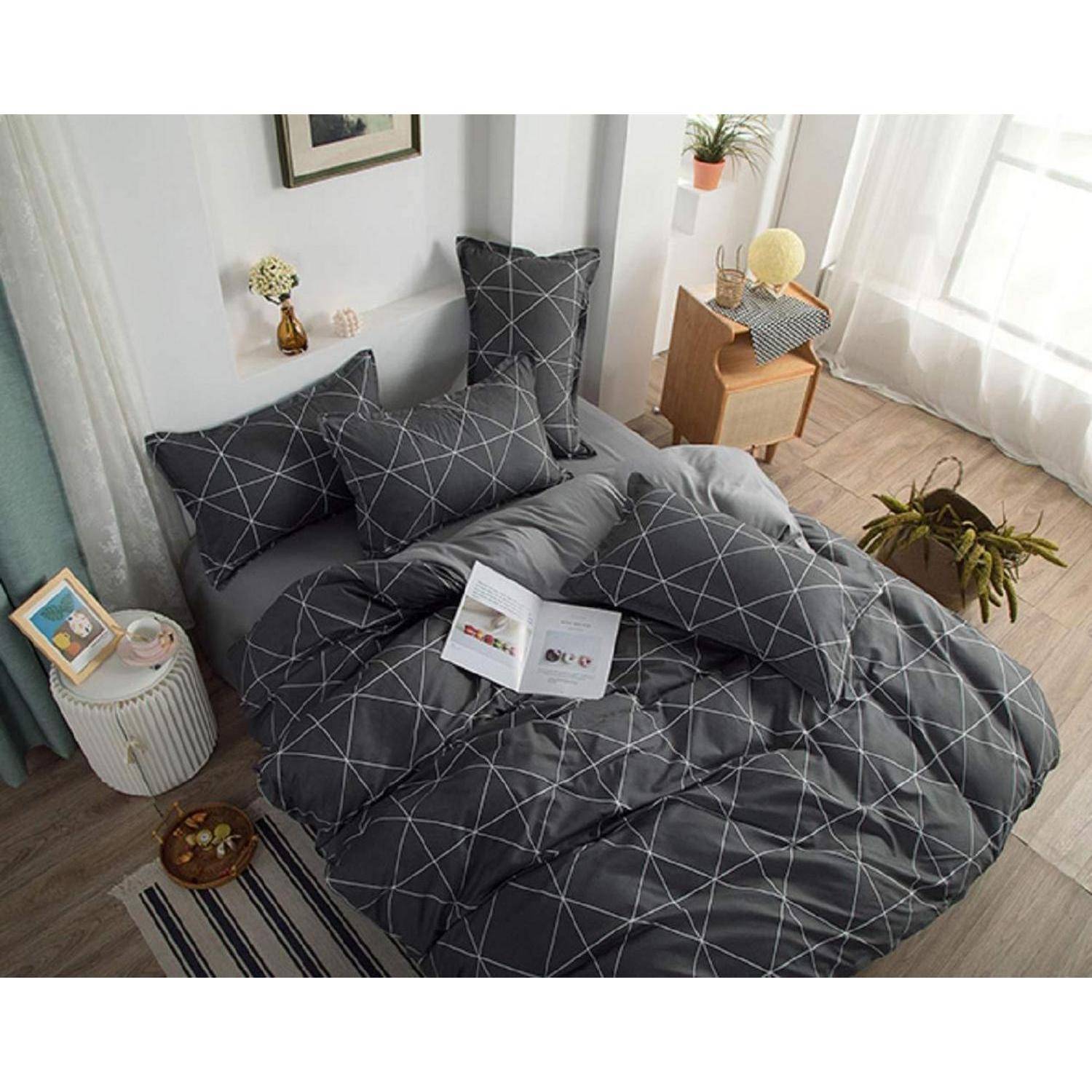 Ein ordentlich gemachtes Bett mit dunkler geometrischer Bettwäsche, Kissen und einem aufgeschlagenen Buch in einem hellen Schlafzimmer neben einem Fenster und kleinen Beistelltischen.