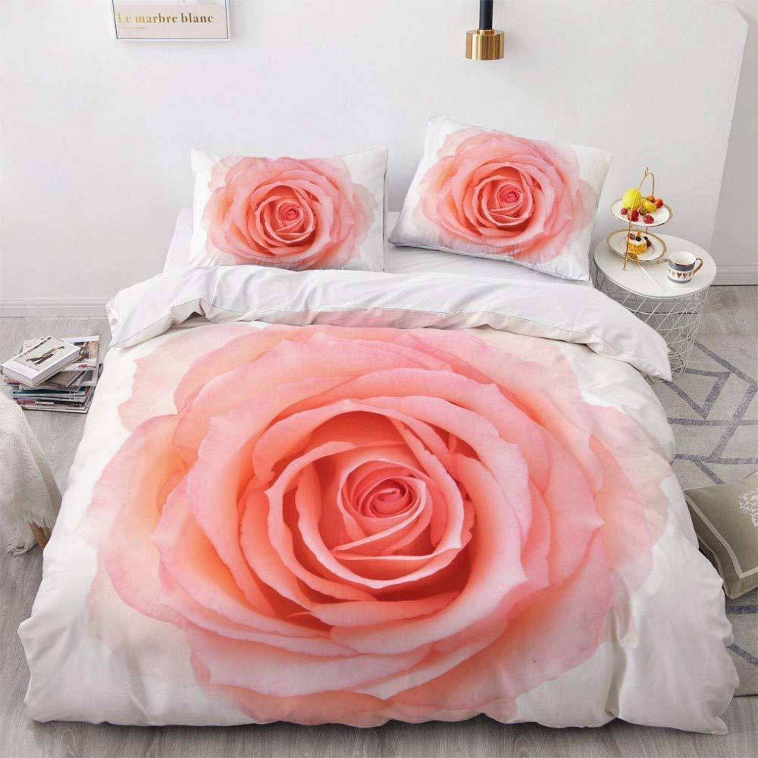 Bett mit weiß bedruckter Bettwäsche mit großen rosa Rosen auf der Bettdecke und Kissenbezügen in einem minimalistischen Schlafzimmer.