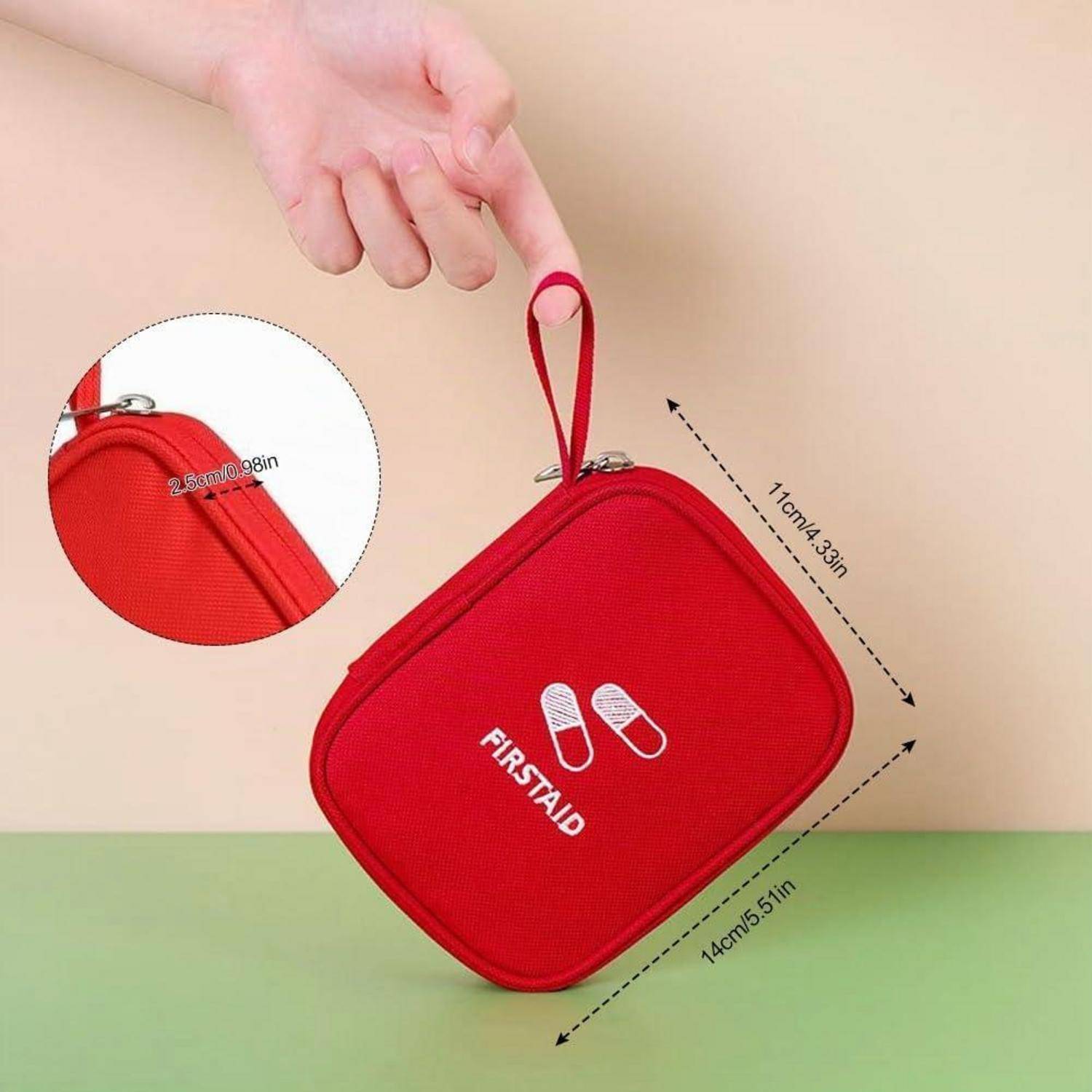 Hand hält eine rote Erste-Hilfe-Tasche mit Reißverschluss und Schlaufengriff; Größenpfeile zeigen etwa 14 cm mal 11 cm, mit einer Nahaufnahme des Reißverschlusses.