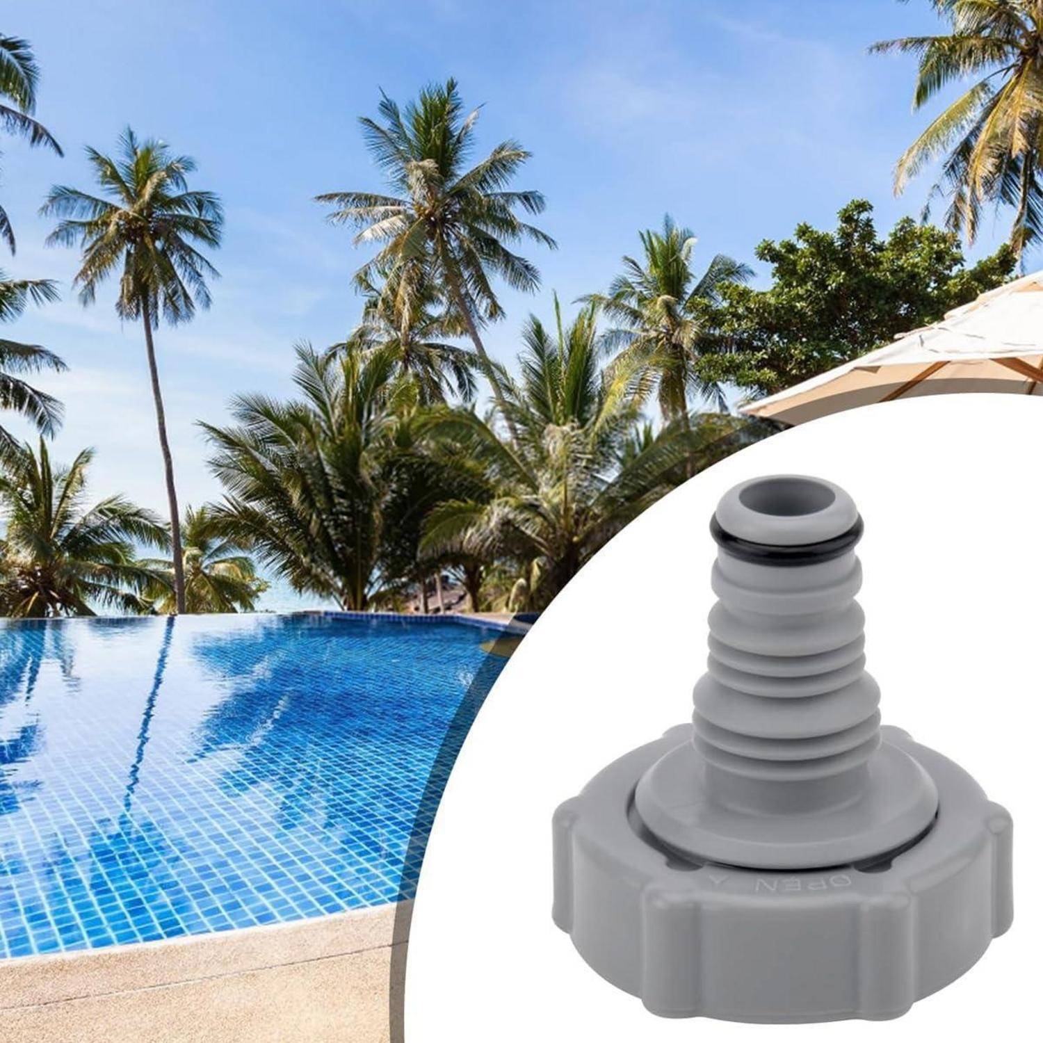 Grauer Gartenschlauchverbinder, gezeigt vor einer Resortpool-Szene mit Palmen und einem Strandschirm im Hintergrund.