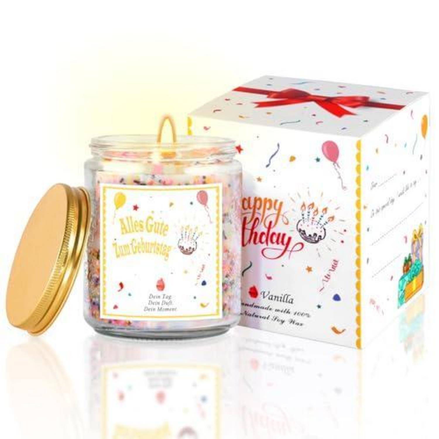 Ein Geburtstagsgeschenkset mit einem Glaskerzenbecher mit Golddeckel und passender dekorierter Schachtel, beschriftet mit „Happy Birthday" und „Alles Gute zum Geburtstag"".
