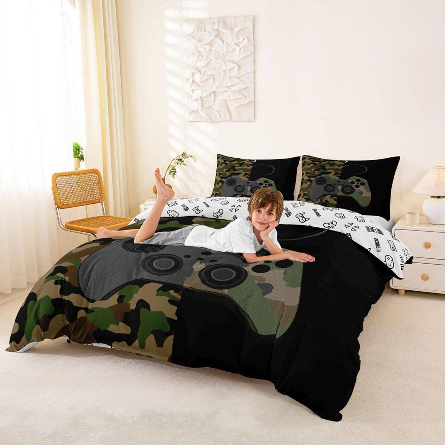 Ein Kind liegt auf einem Bett mit schwarzer Tarnbettdecke und schwarz-weißen Kissen in einem hellen Schlafzimmer.