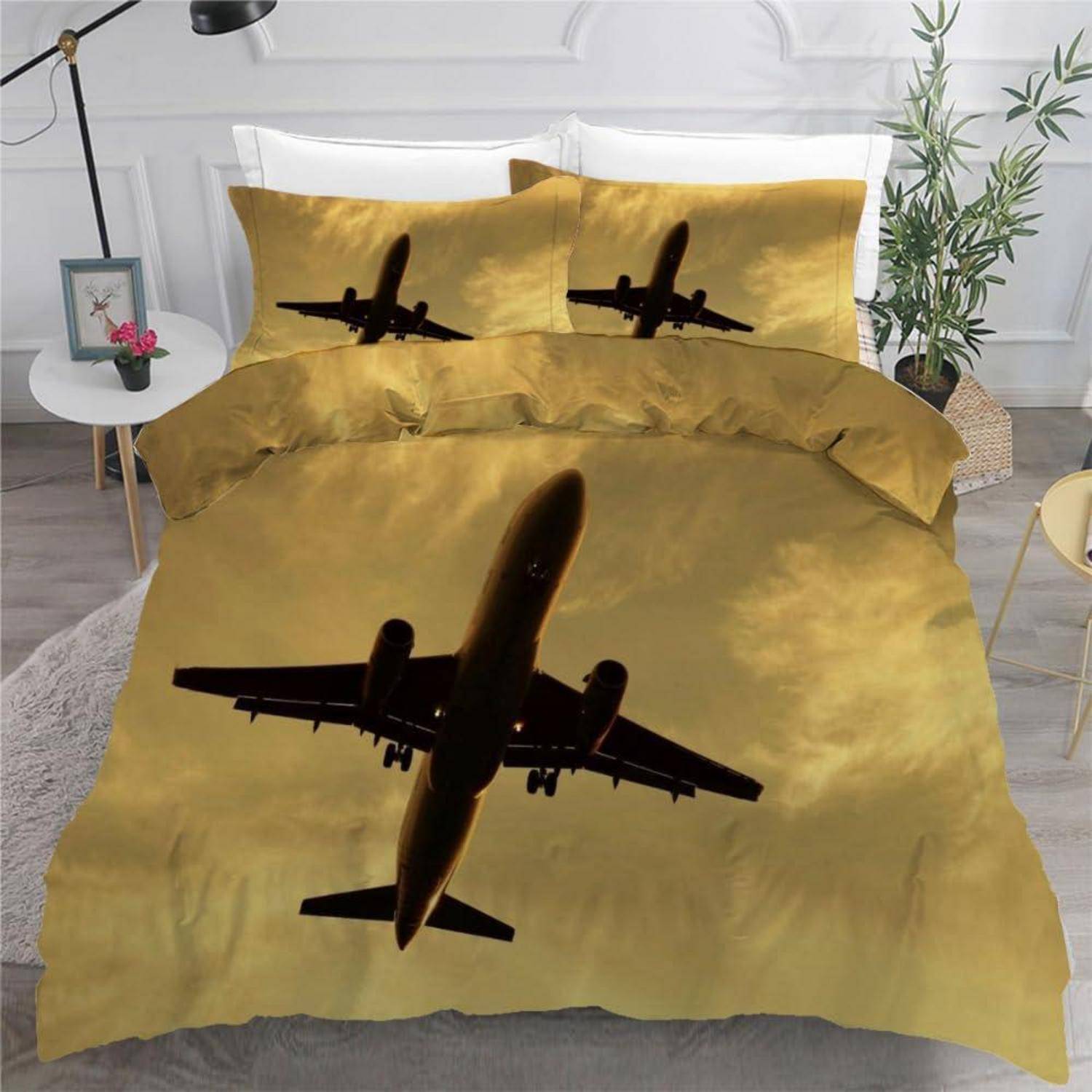 Flugzeug-inspiriertes Bettwäscheset in Gold mit schwarzer Düsenflugzeug-Silhouette auf der Bettdecke und passenden Kissenbezügen.