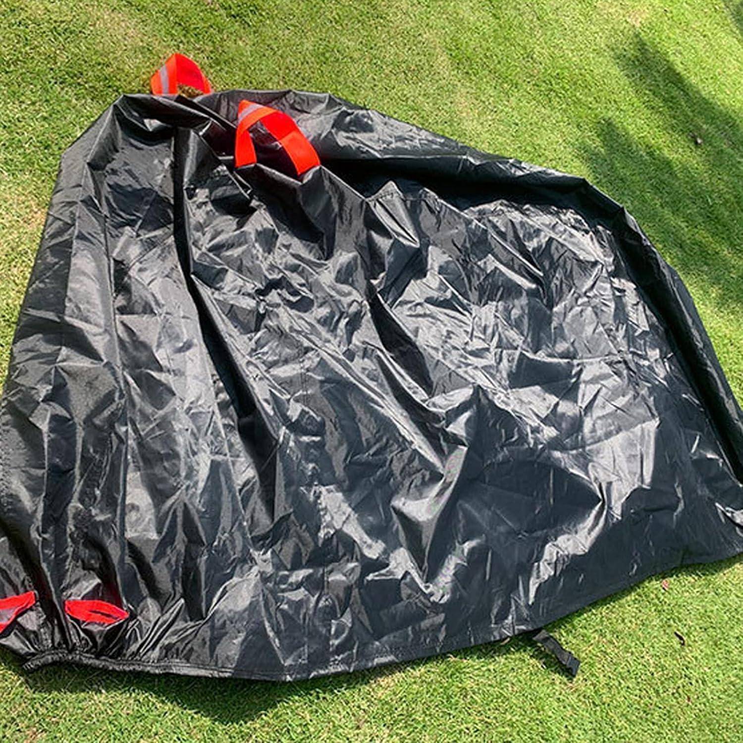 Schwarze Stoffabdeckung oder Bodenplane mit roten Griffen, die auf Gras im Freien liegt