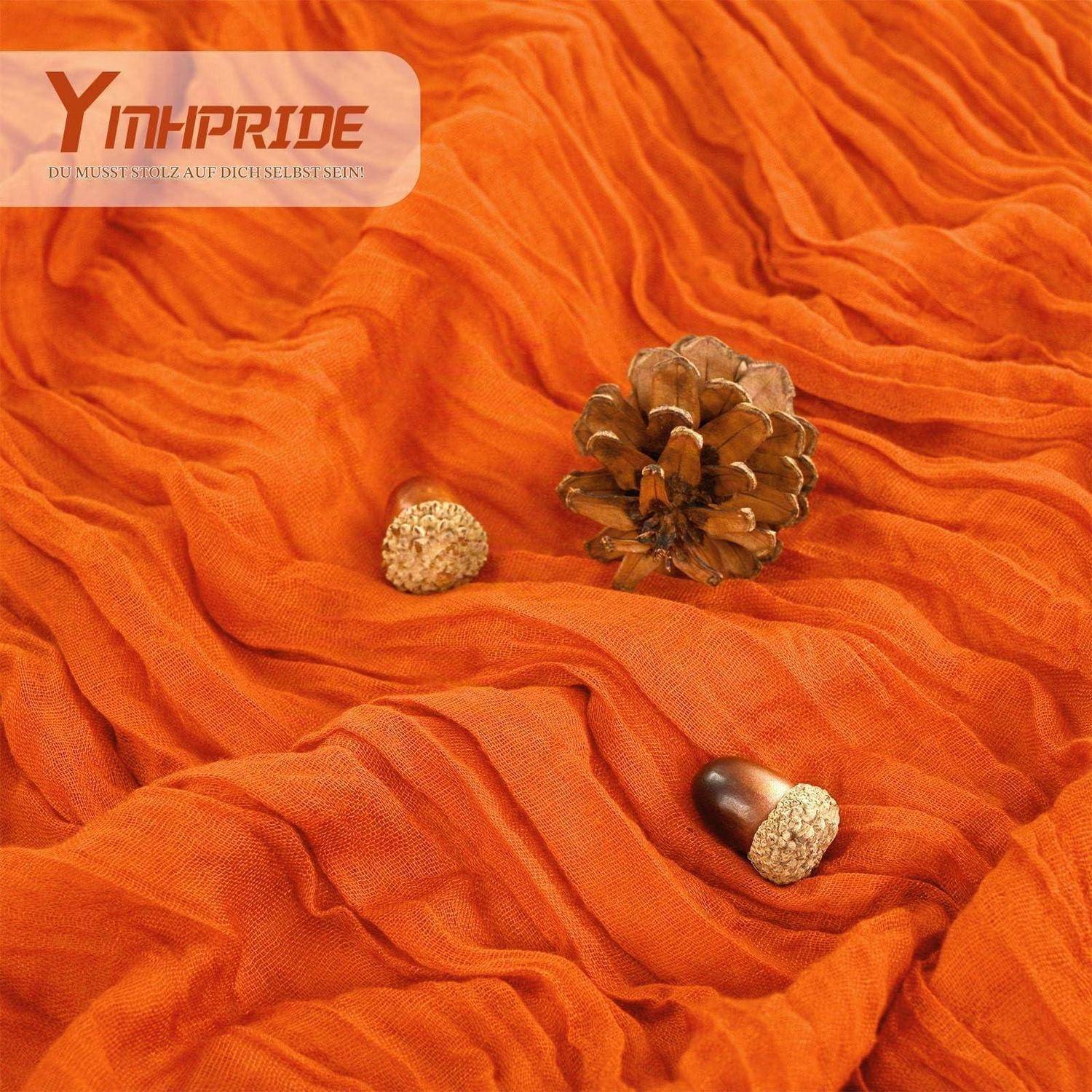 Orangefarbener zerknitterter Stoff mit einer Tannenzapfen und zwei Eicheln, mit dem "Yinhipride""-Logo in der oberen linken Ecke.
