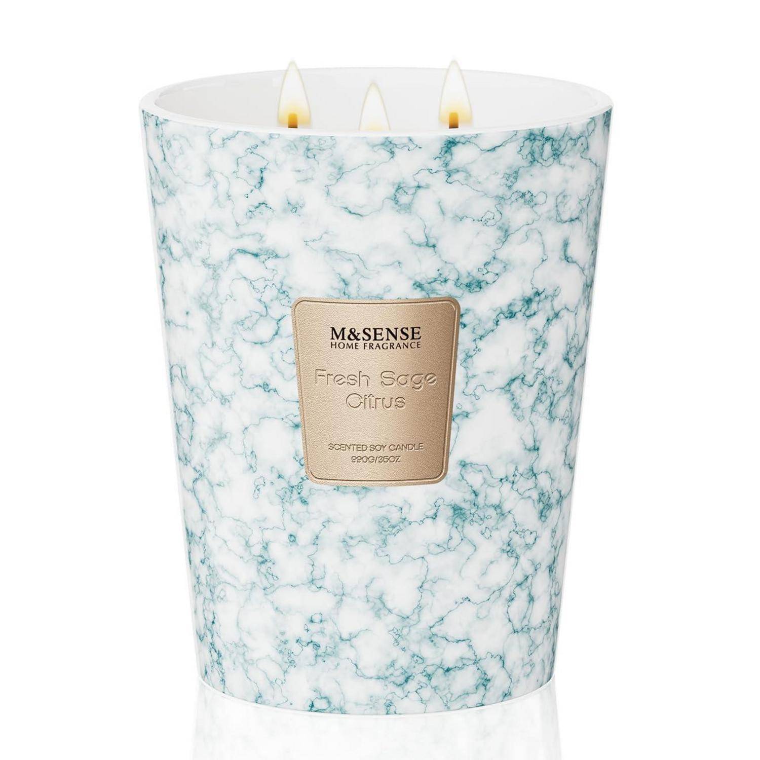 Eine dreiochtige Duftkerze in einem weiß-blaugrün marmorierten Glaskrug mit der Aufschrift „M&S Sense Home Fragrance Fresh Sage Citrus